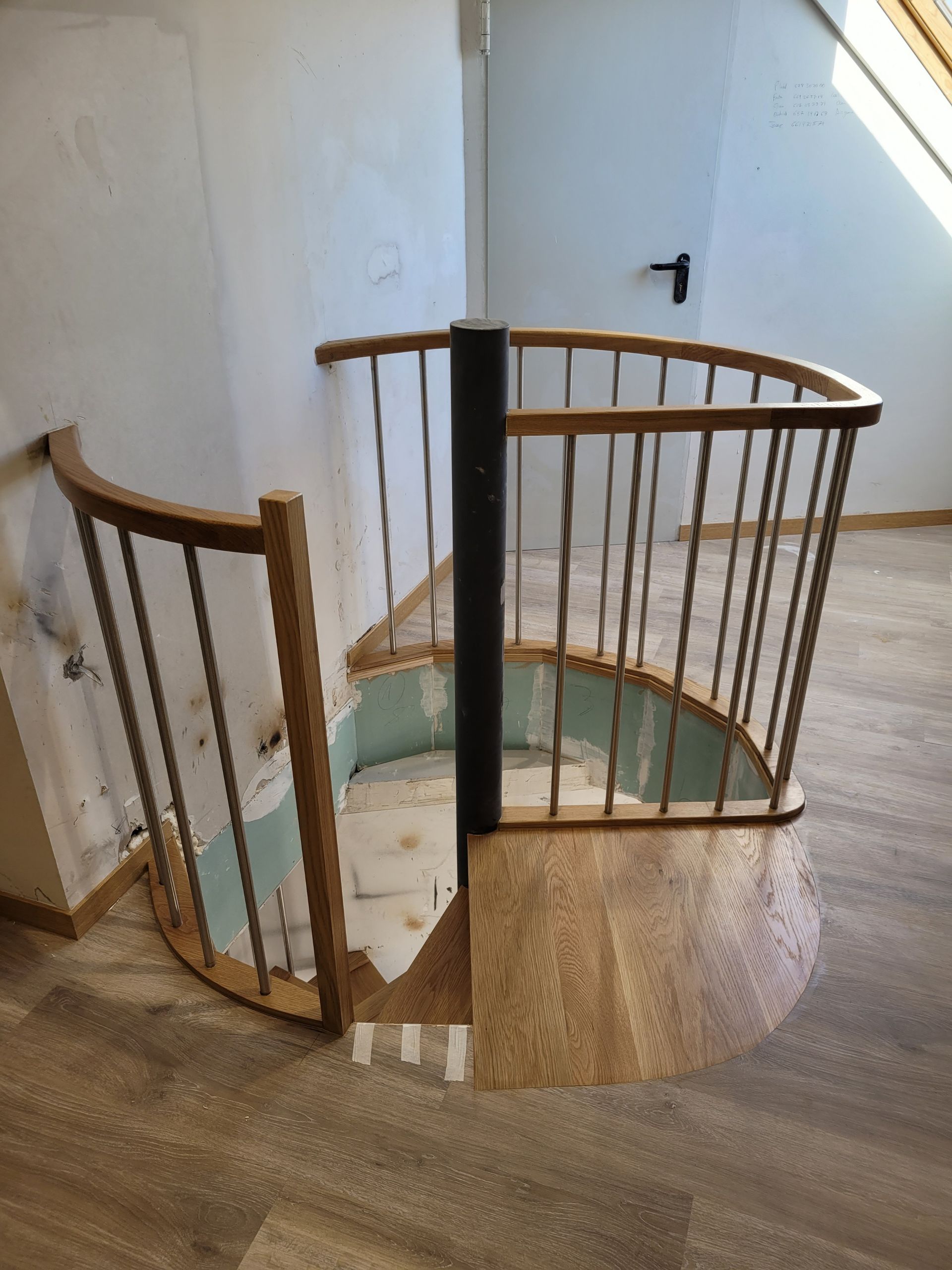 Una escalera de caracol con barandilla de madera en una habitación.