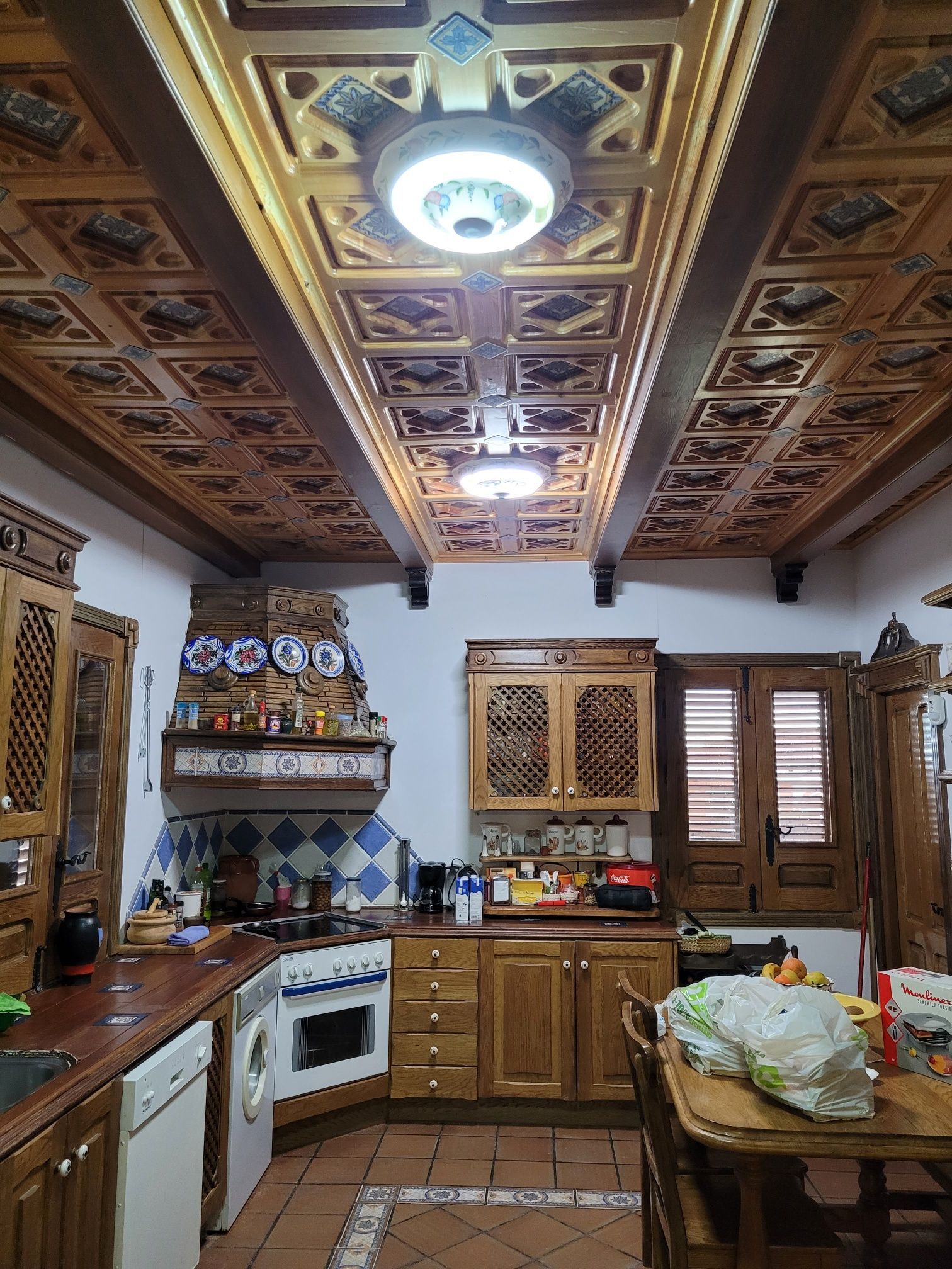Una cocina con gabinetes de madera y techo de madera.