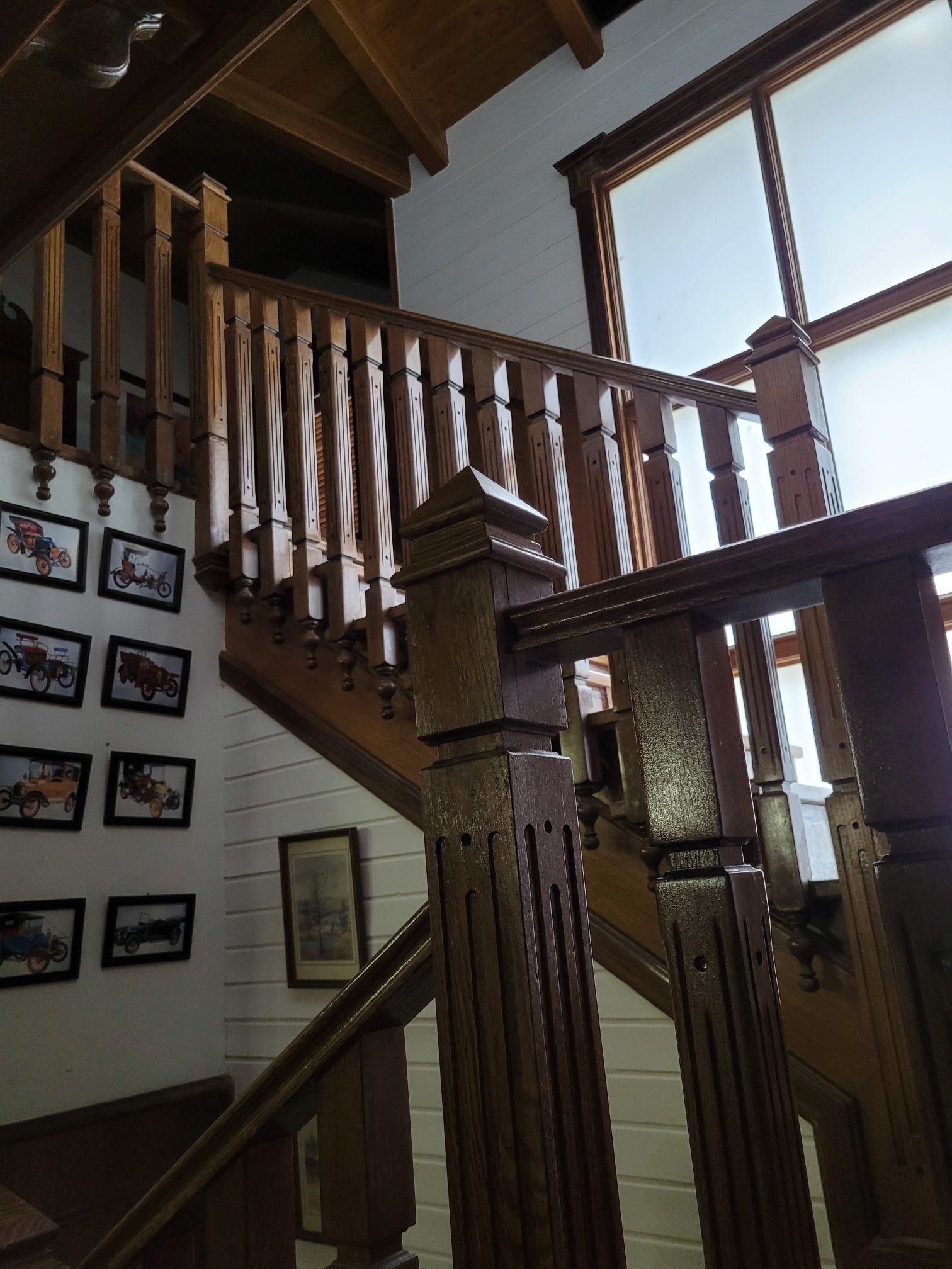 Una escalera de madera con cuadros en la pared detrás de ella.