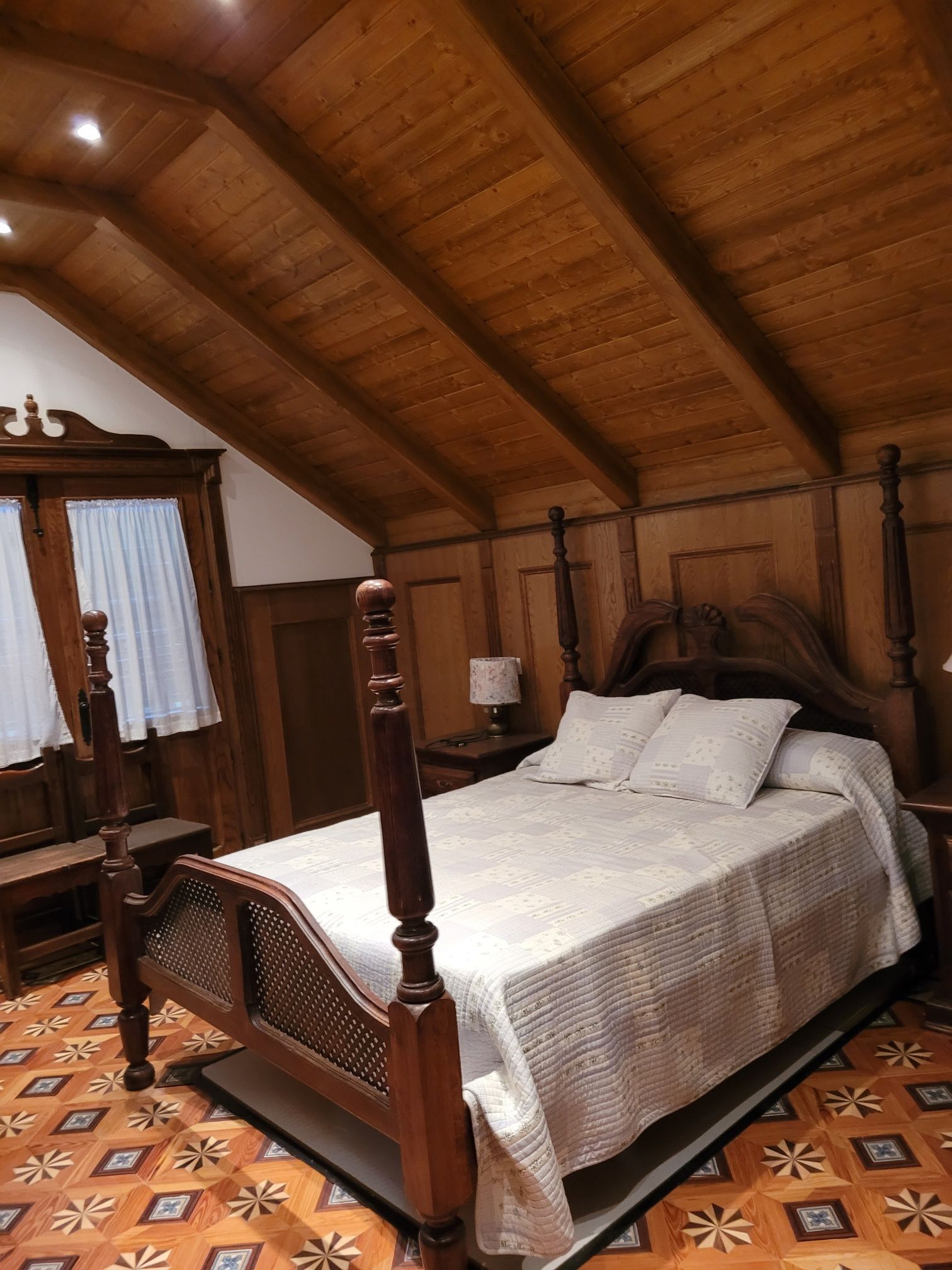 Un dormitorio con una cama con dosel y un techo de madera.