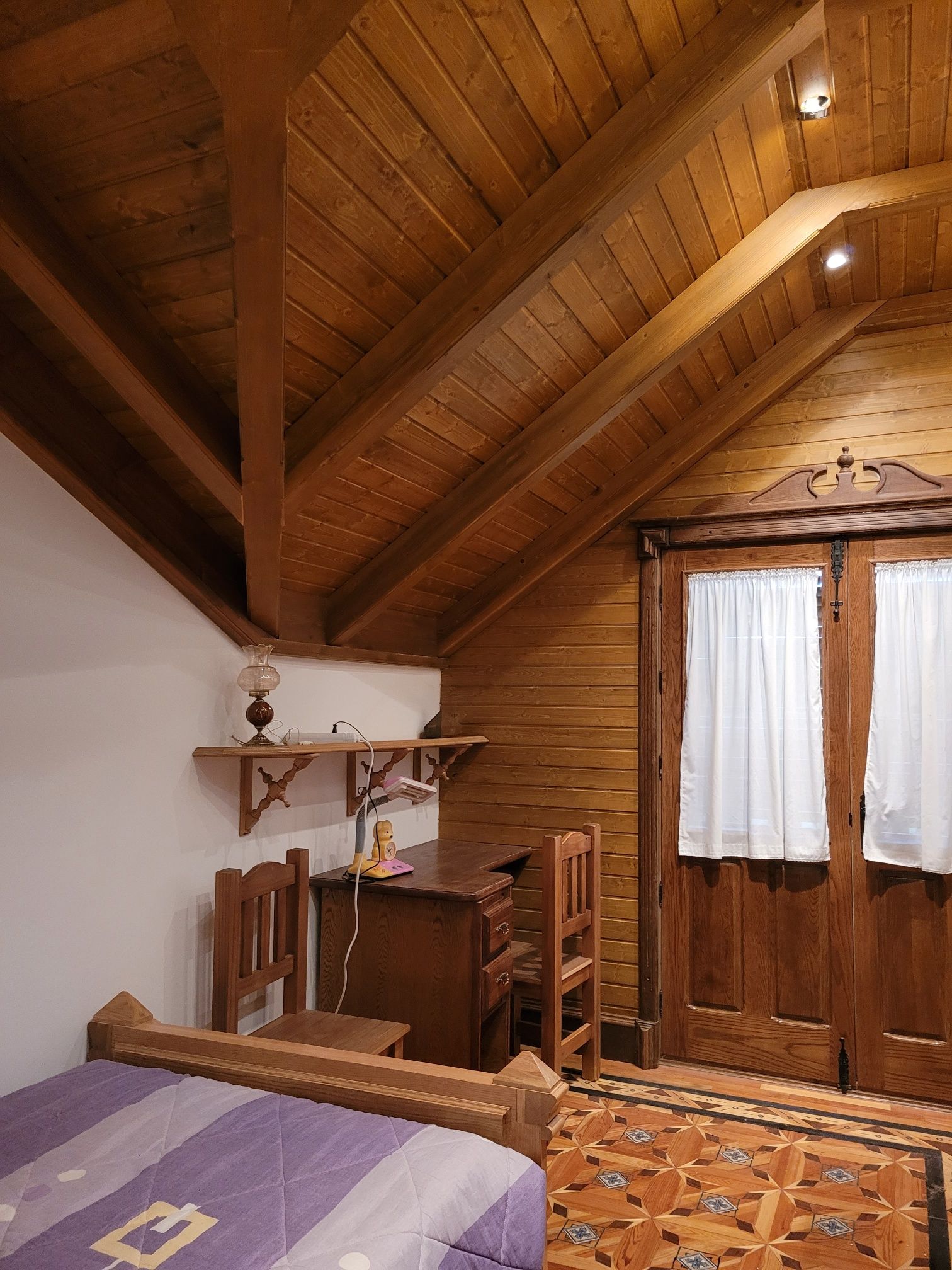 Un dormitorio con una cama morada y un escritorio.