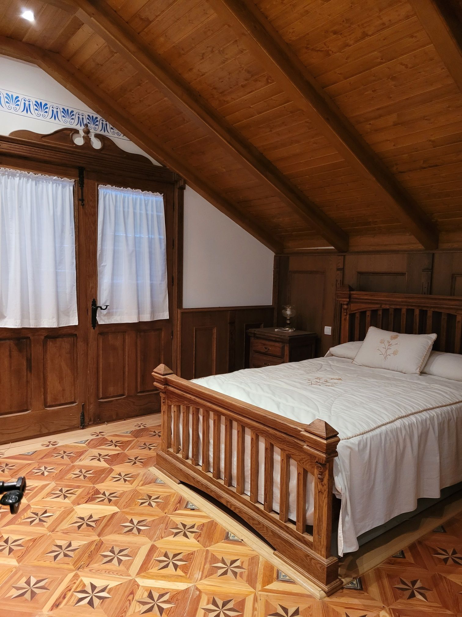 Un dormitorio con una cama de madera y un suelo estampado.