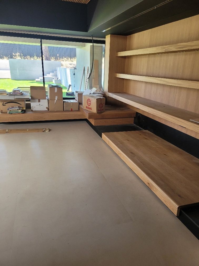 Una sala de estar con estantes de madera y cajas en el suelo.