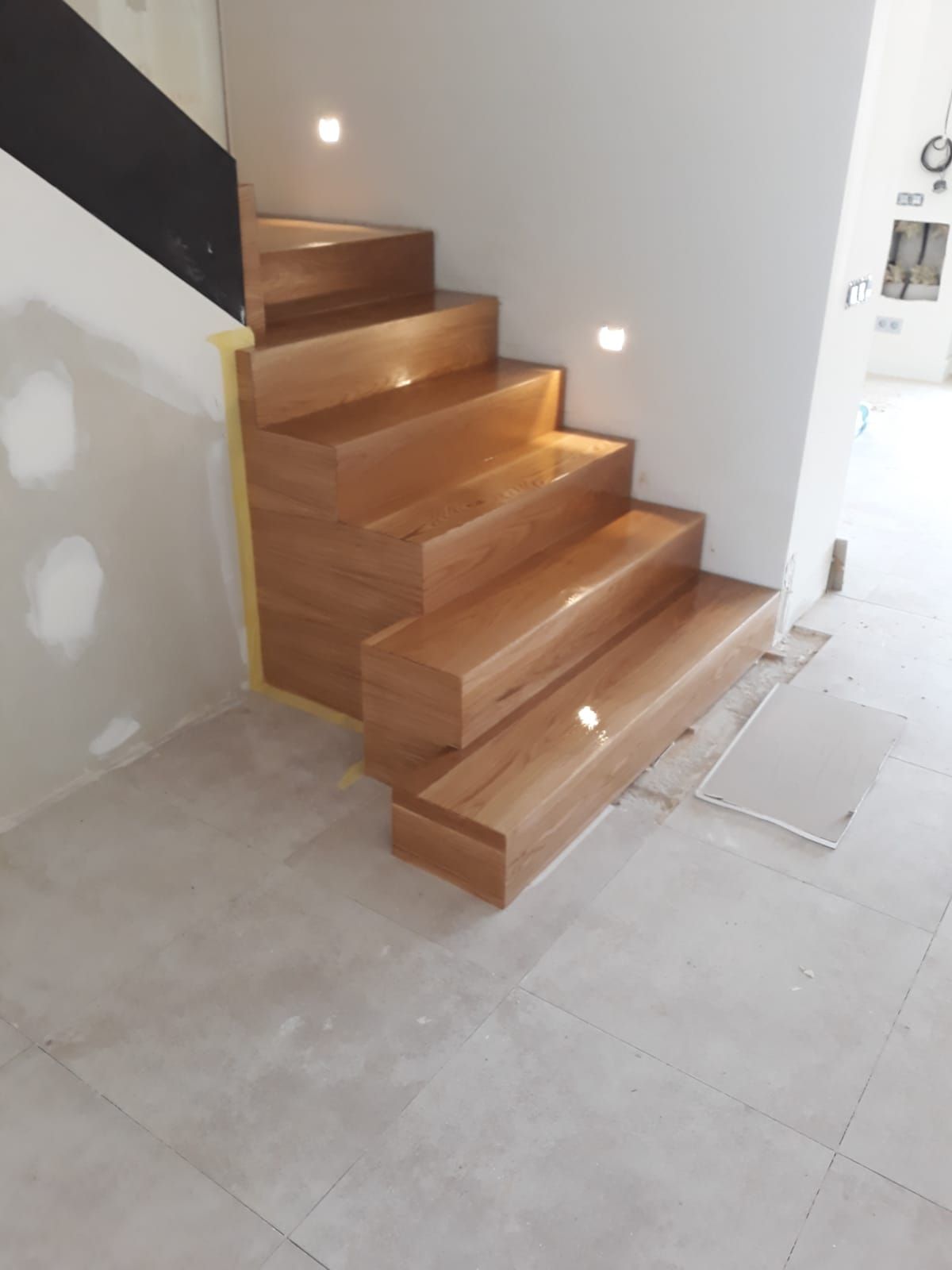 Una escalera de madera con luces en los escalones.