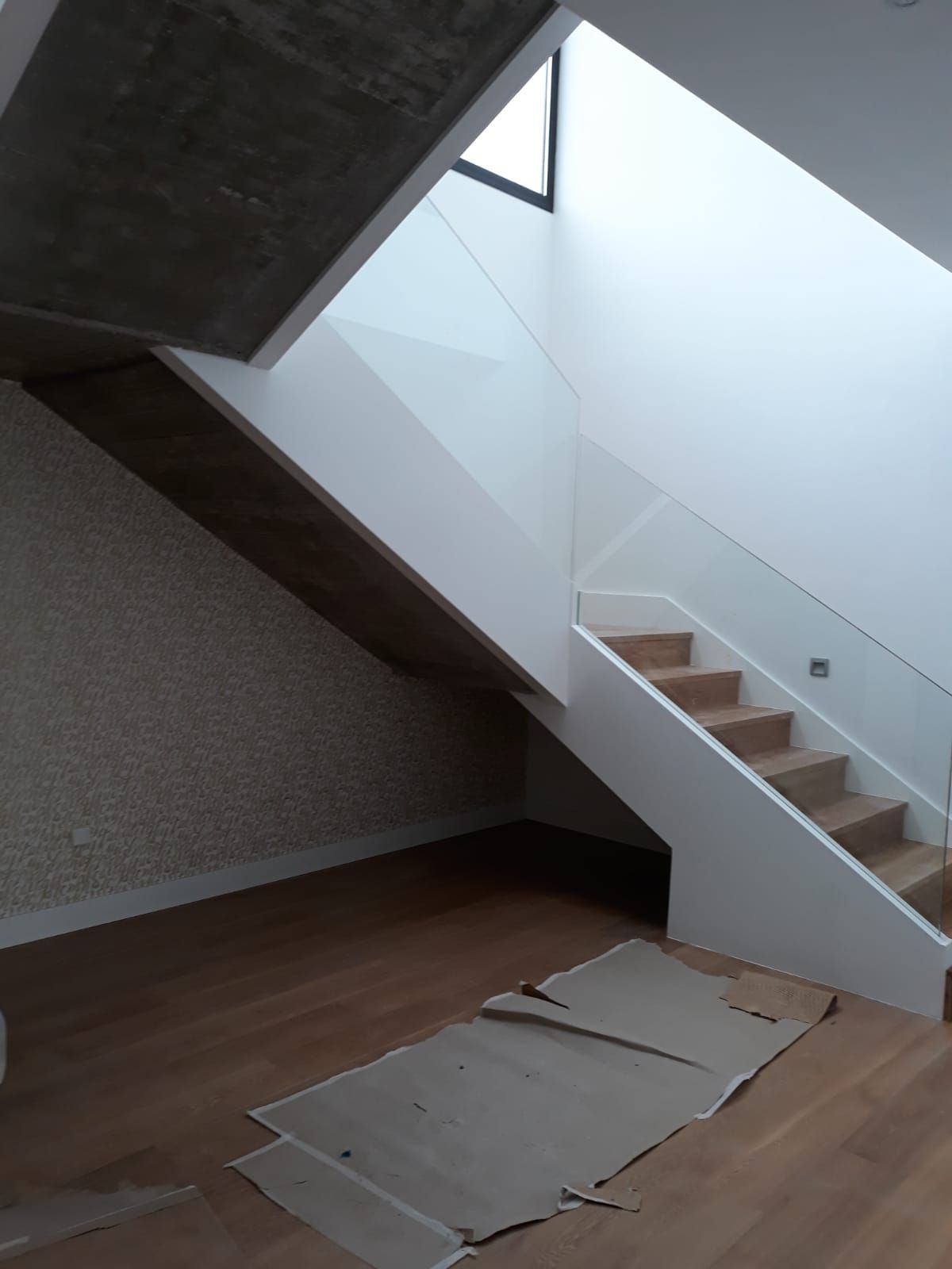 Una habitación vacía con una escalera y una ventana.
