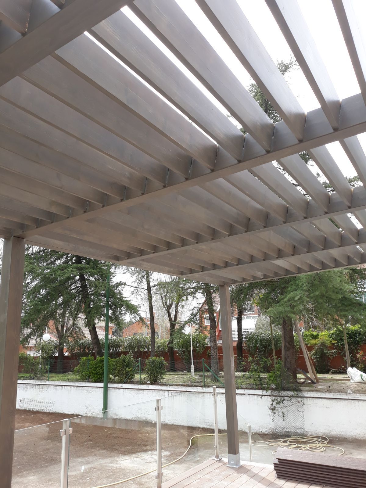 Una pérgola con vista a un parque y árboles.