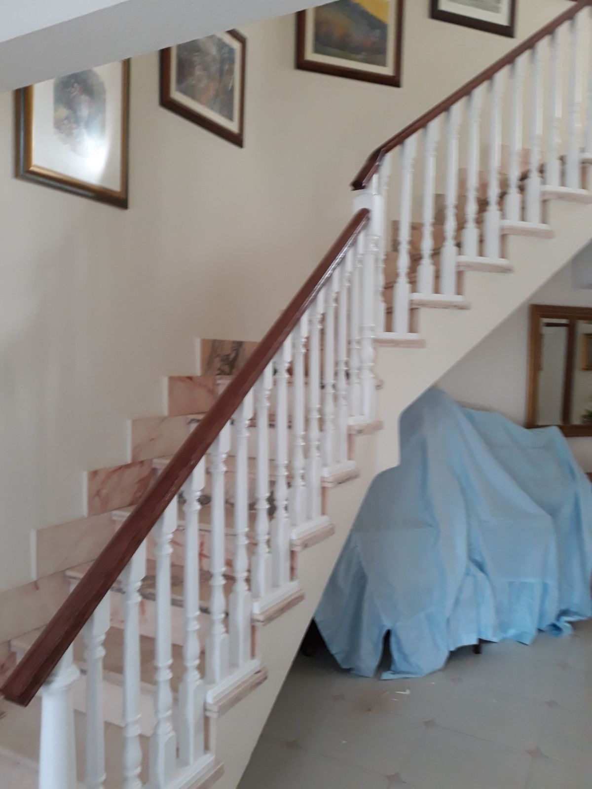 Una escalera con barandillas blancas y pasamanos de madera