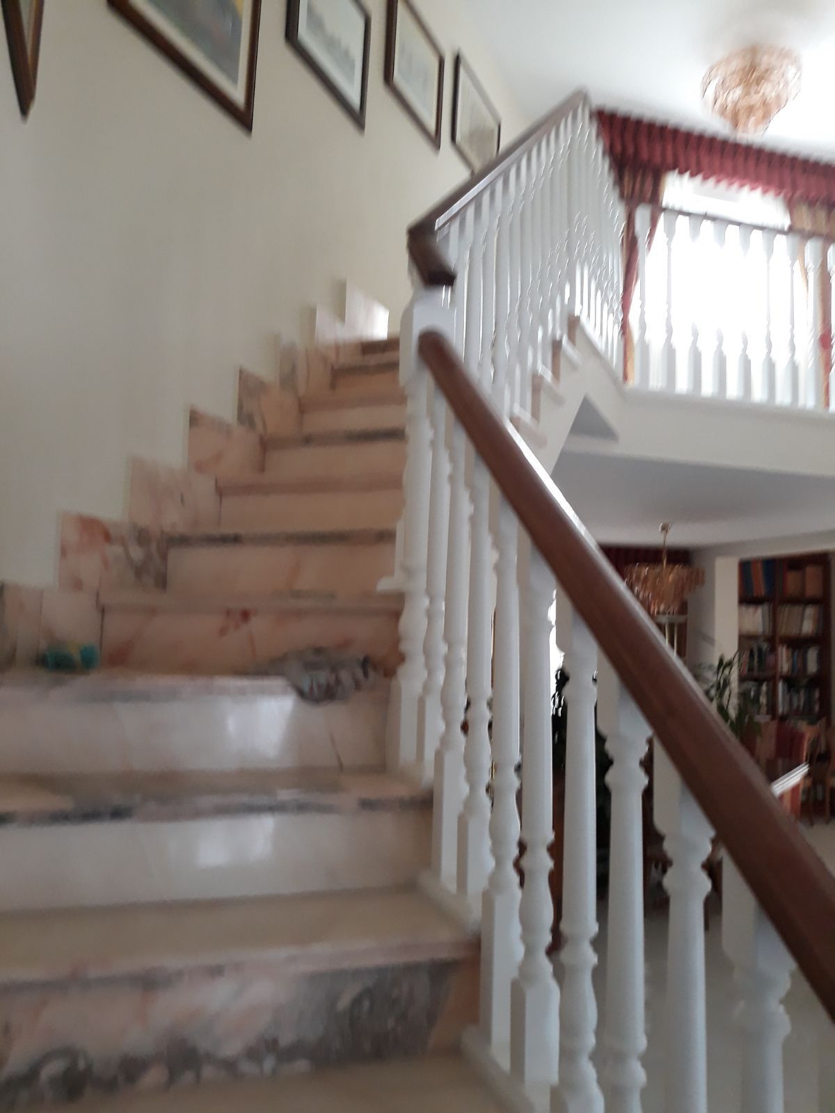 Una escalera con barandilla blanca y pasamanos de madera