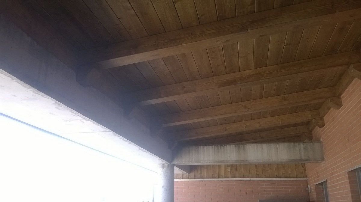 El techo de un edificio con vigas de madera y una pared de ladrillo.