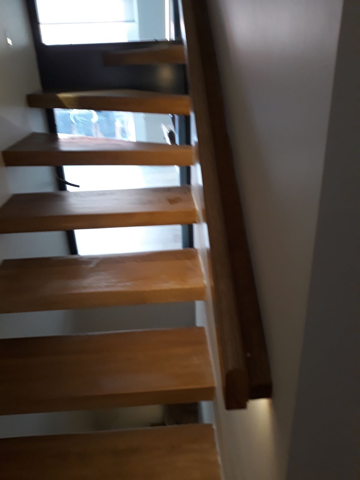 Un conjunto de escaleras de madera que conducen a una ventana.