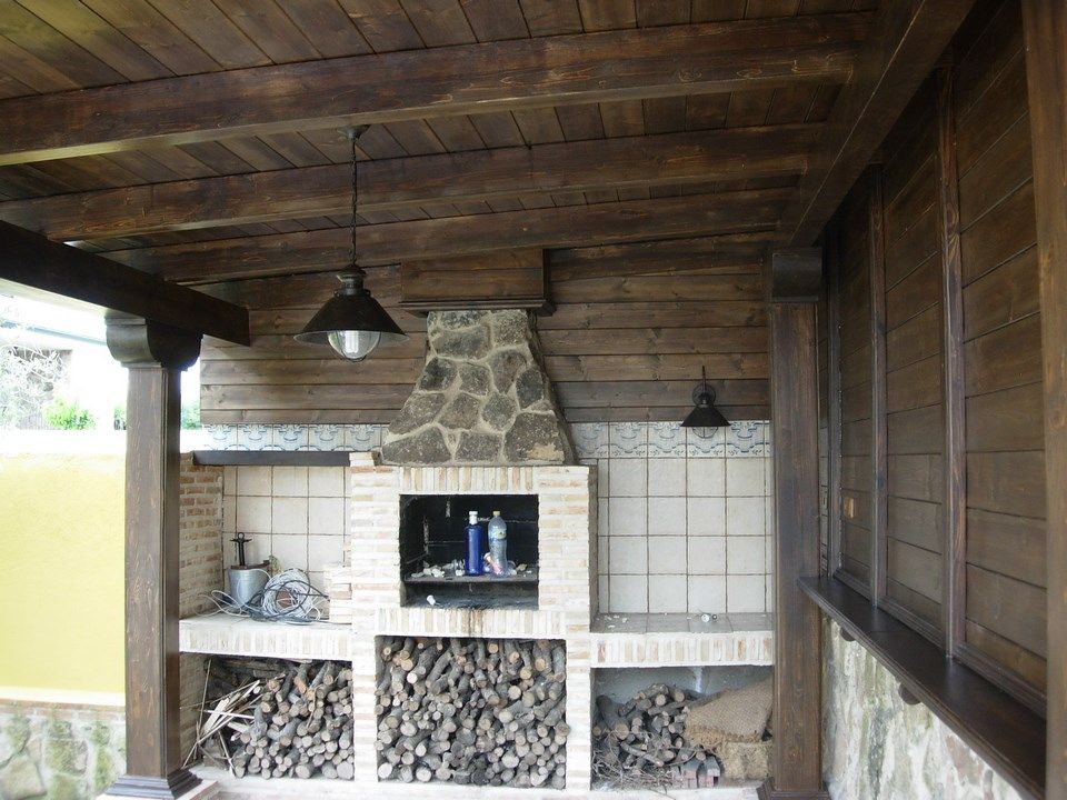 Un área cubierta de madera con una chimenea de ladrillo