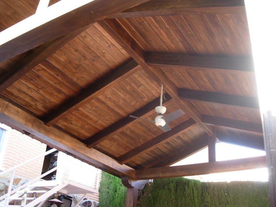 Un techo de madera con un ventilador de techo colgando de él.