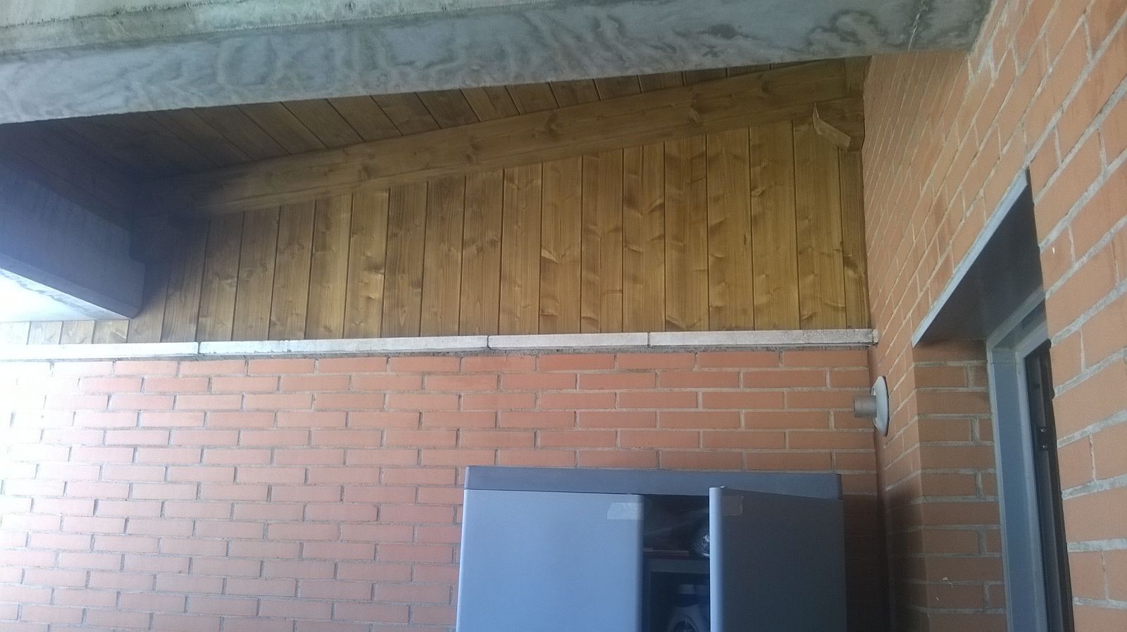 Una pared de ladrillos con un armario debajo.