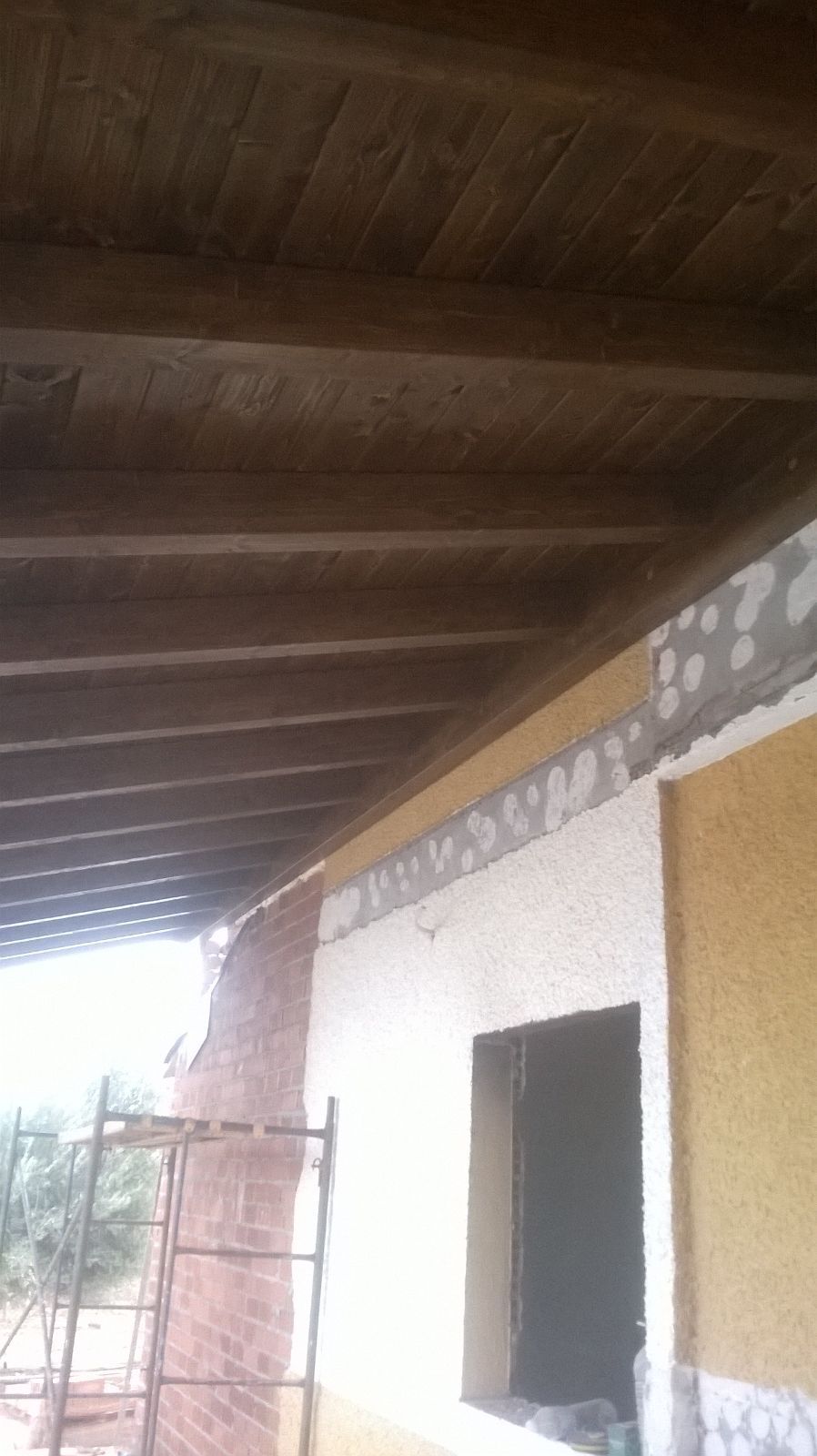 Un edificio en construcción con techo de madera y una ventana.