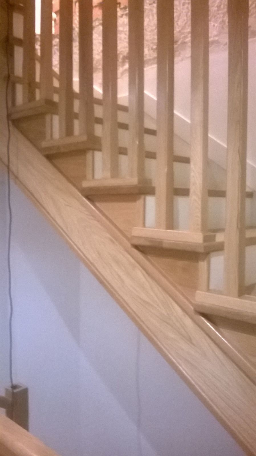 Un primer plano de una escalera de madera con barandilla.