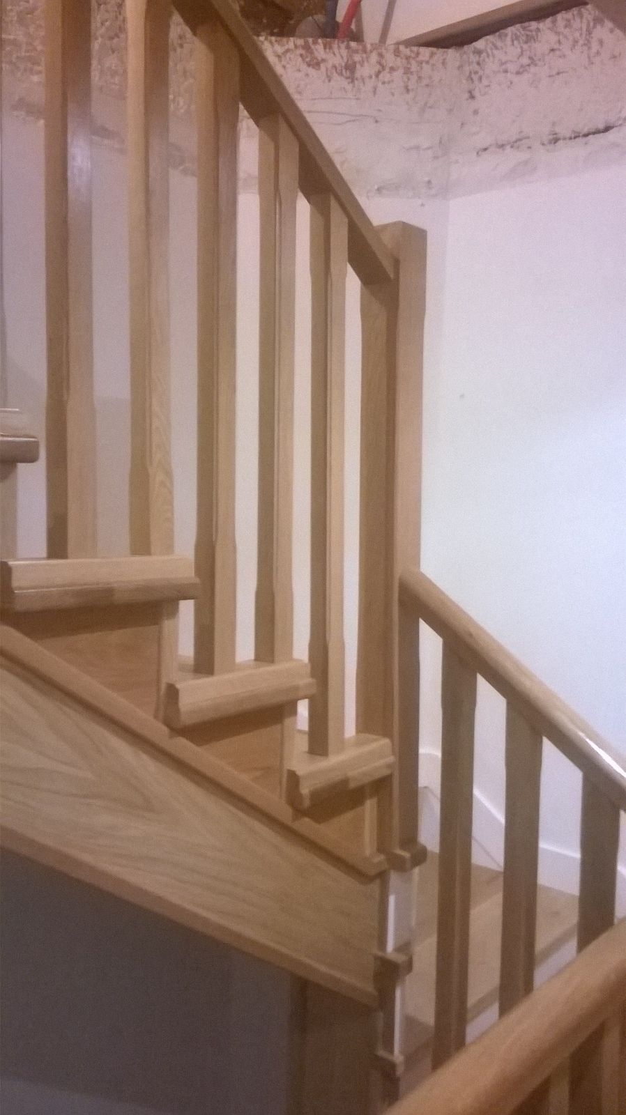 Una escalera de madera con barandilla de madera en una casa.