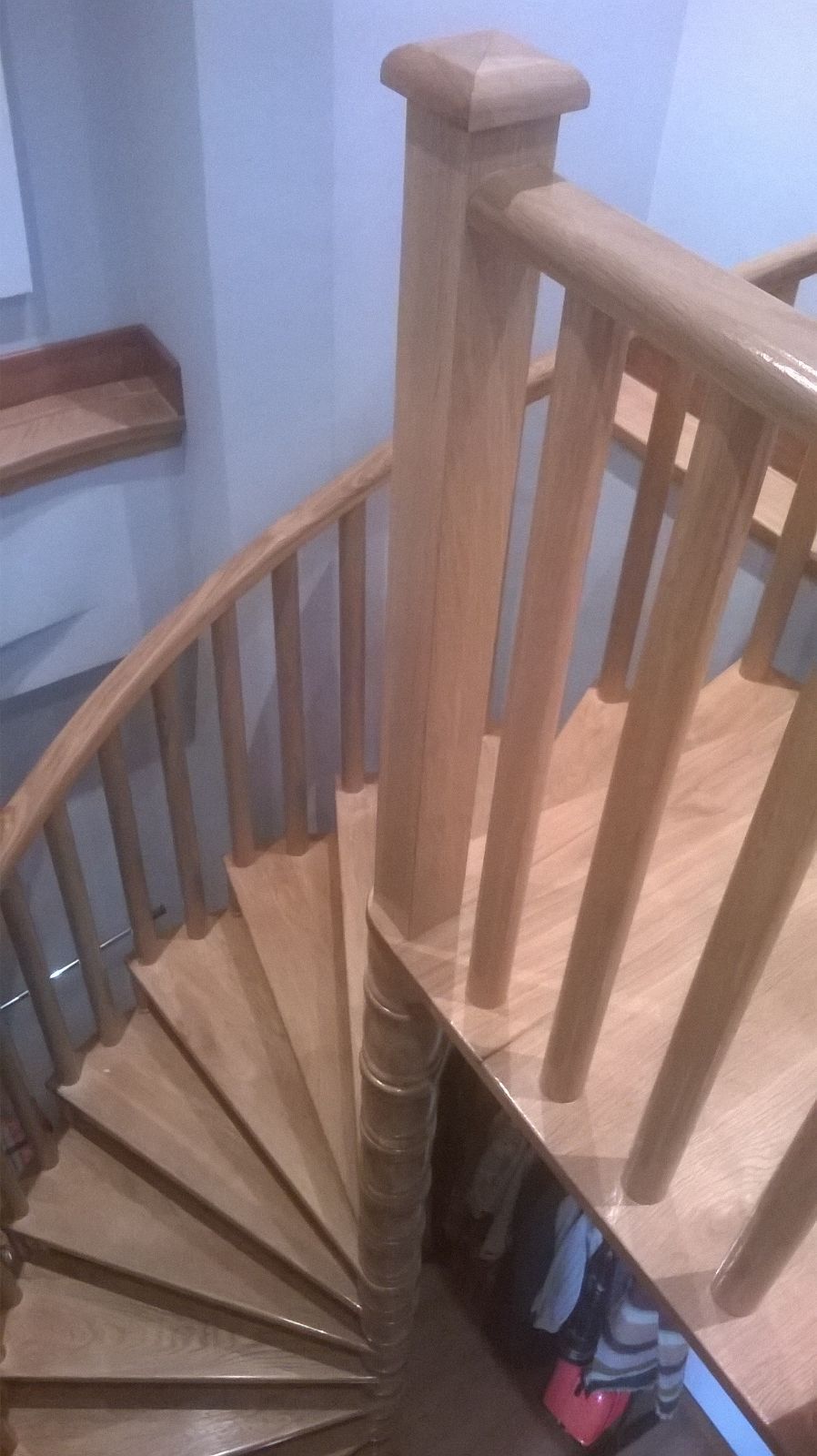 Un primer plano de una escalera de caracol de madera con barandilla de madera.