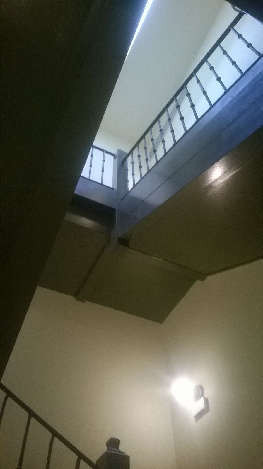Mirando hacia arriba a una escalera con barandilla y una ventana