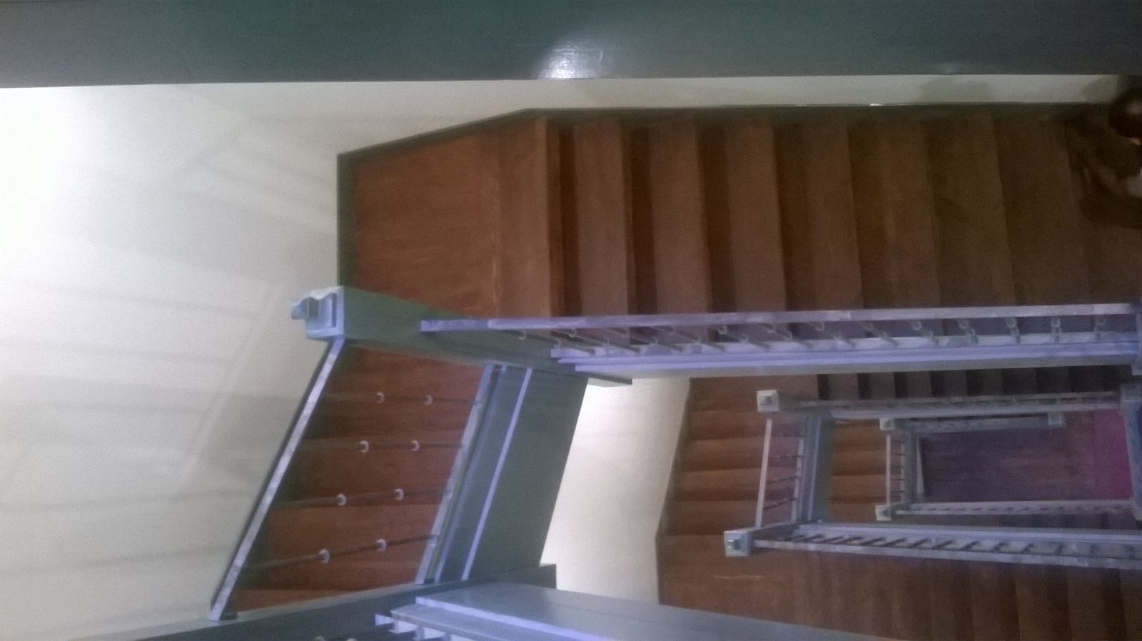 Una escalera está colocada delante de una pared de madera en una habitación.