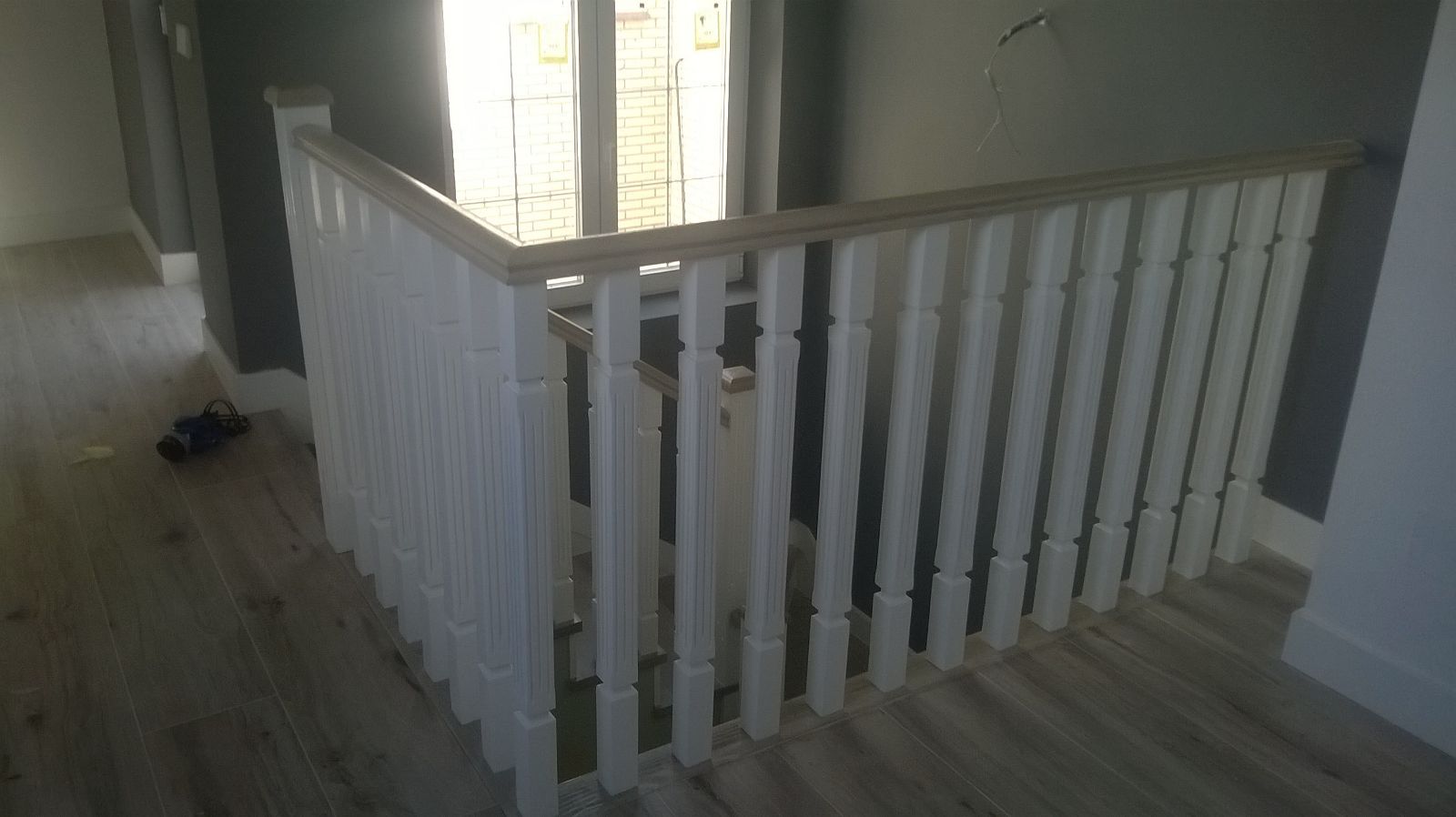 Una barandilla blanca en una escalera de madera de una casa.