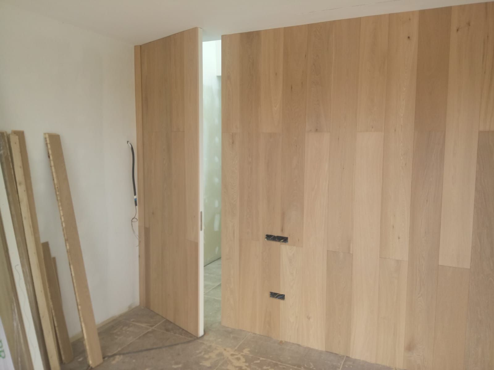 Una habitación con una pared de madera y una puerta de madera.
