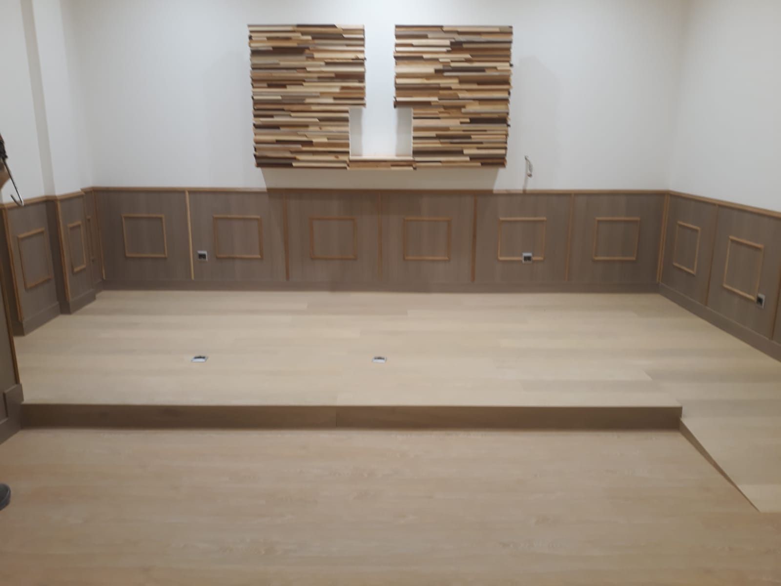 Una habitación vacía con suelo de madera y una pared de madera.