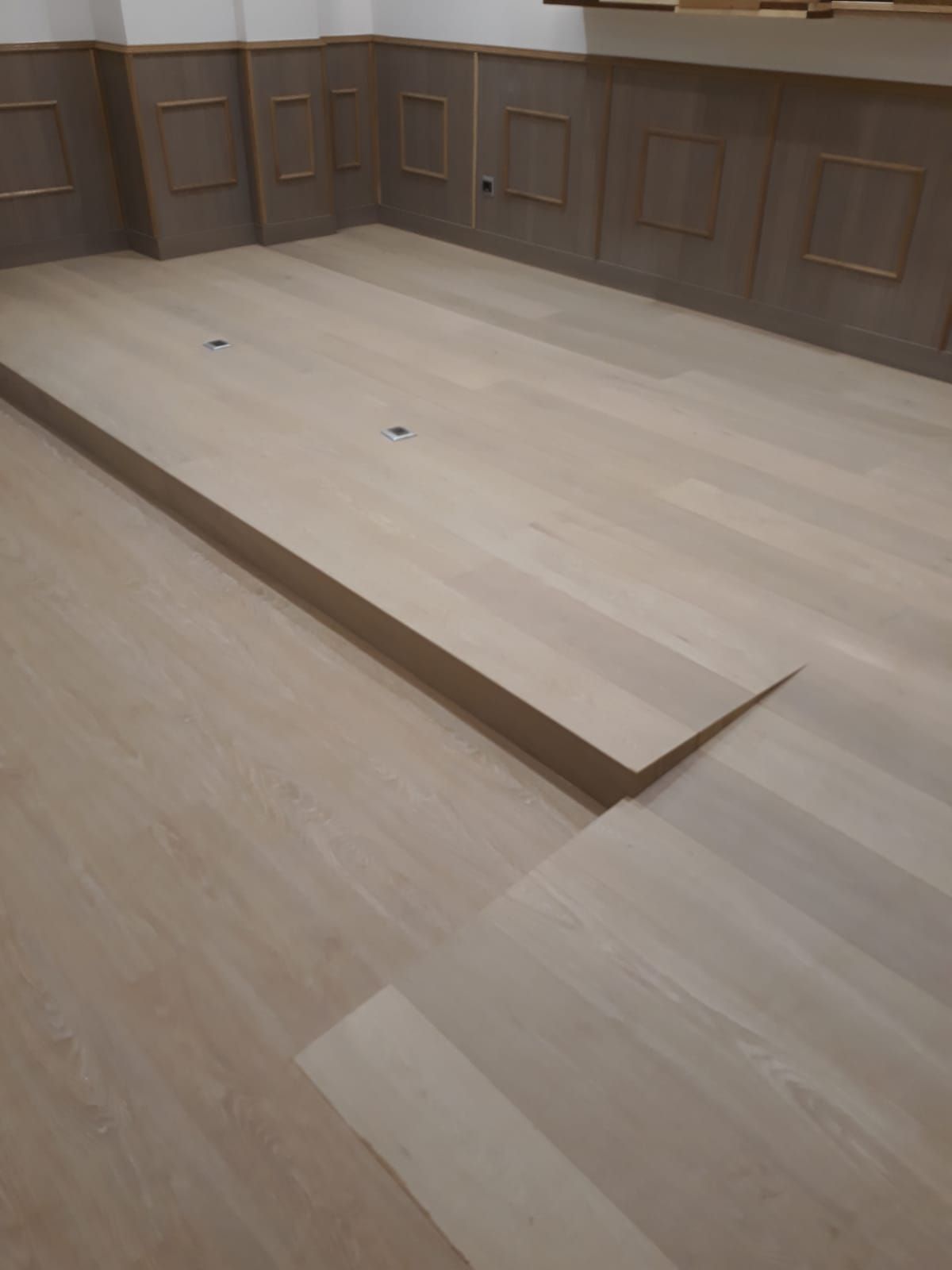 Una habitación con suelo de madera y escaleras.