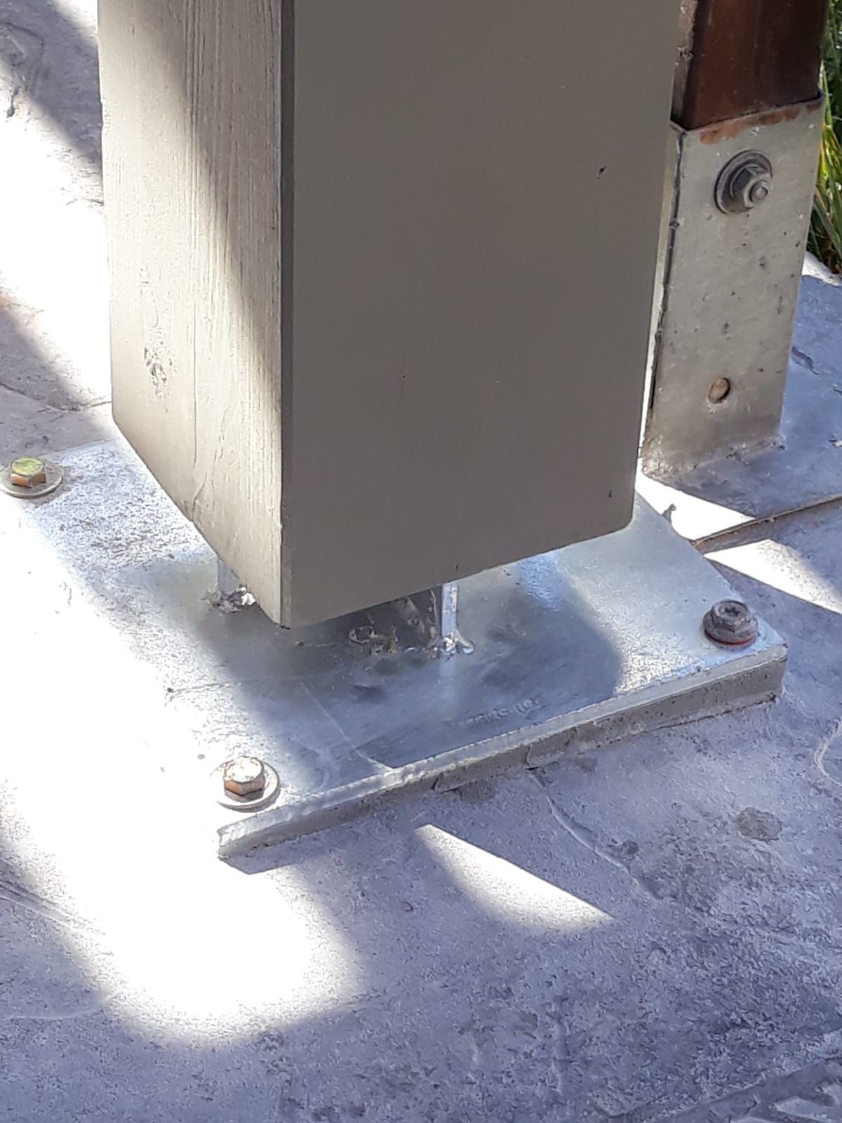 Un poste de metal está colocado encima de una base de hormigón.