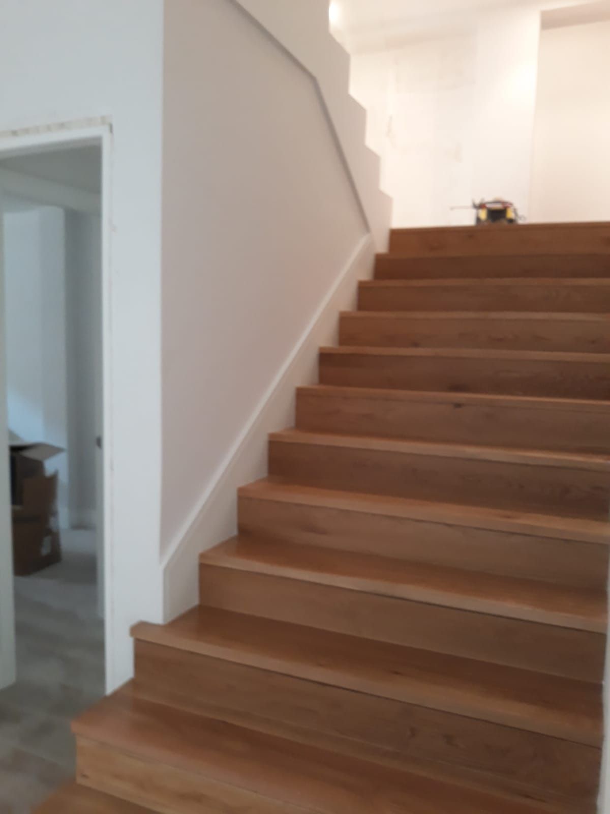 Un conjunto de escaleras de madera con barandilla blanca.