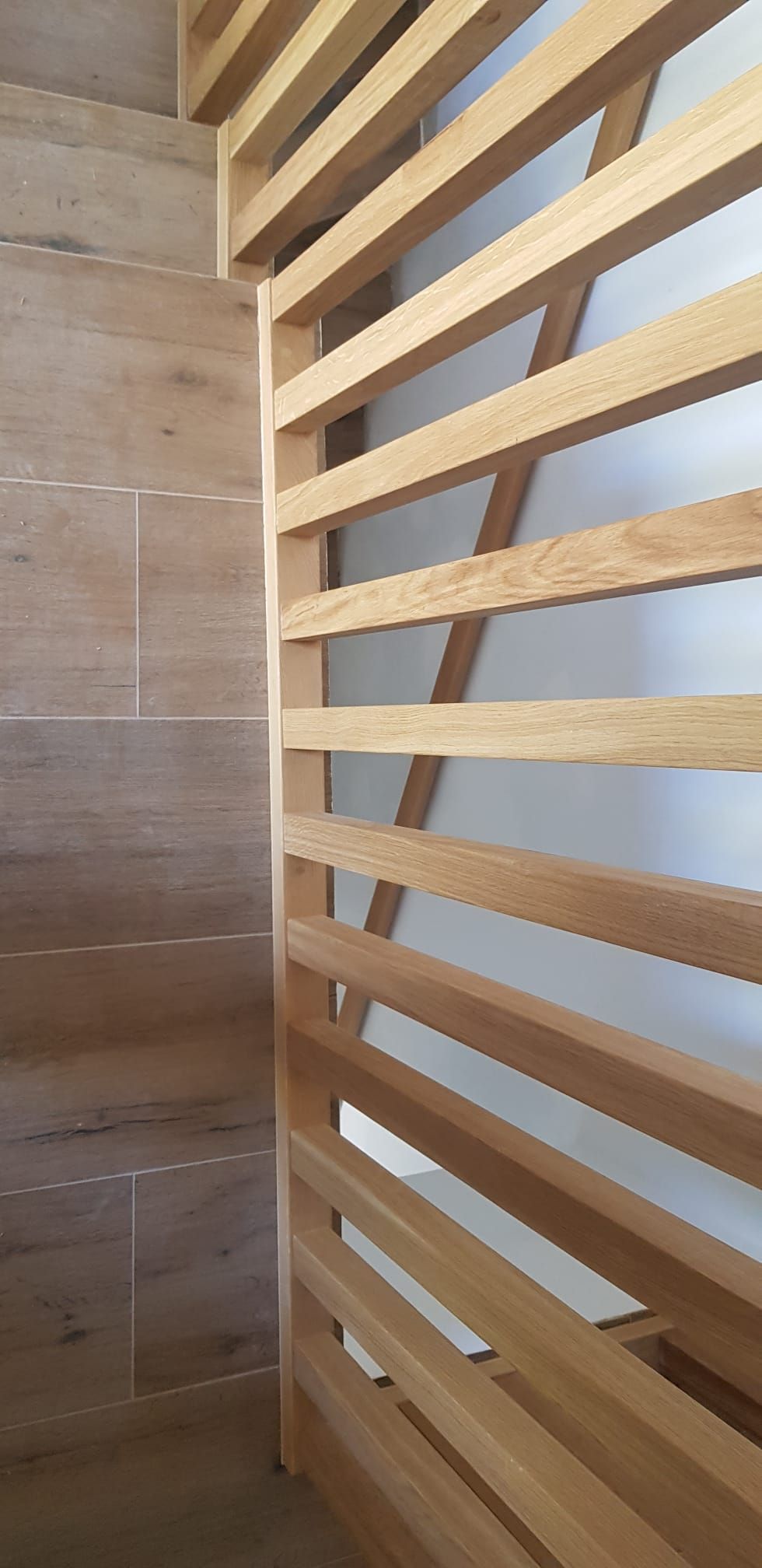 Un primer plano de una barandilla de madera junto a una escalera.