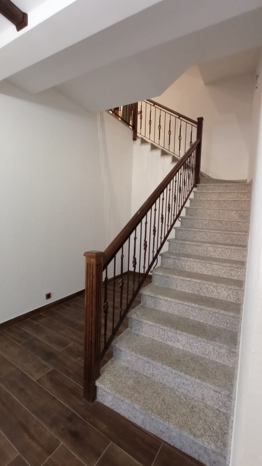 Una escalera con barandilla de madera en una habitación.