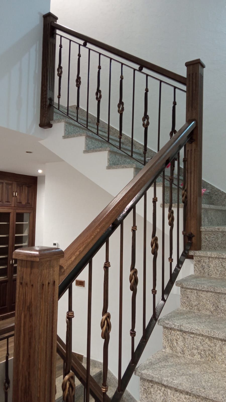 Una escalera con barandilla de madera y barandilla de metal