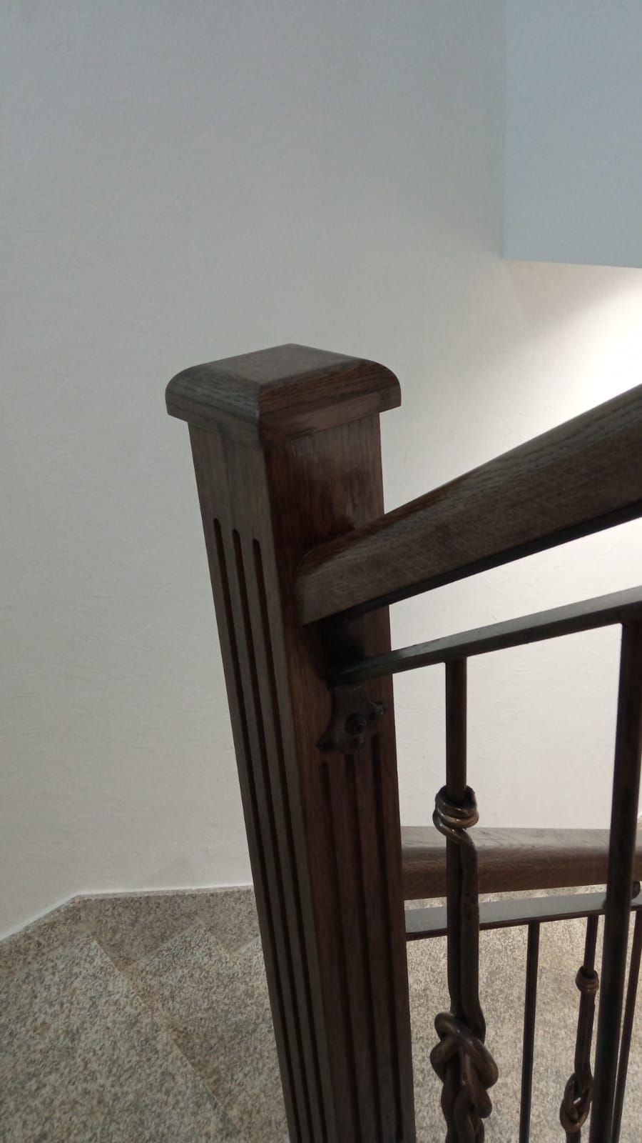 Un primer plano de una barandilla de madera en una escalera.