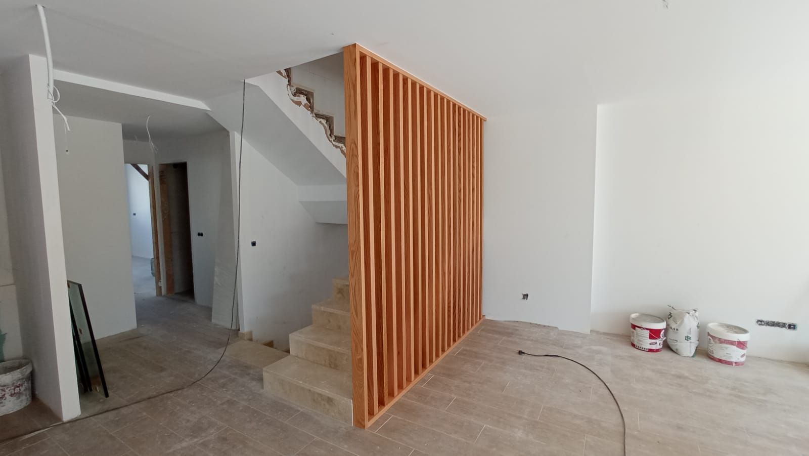 Una habitación con una escalera y un divisor de madera.