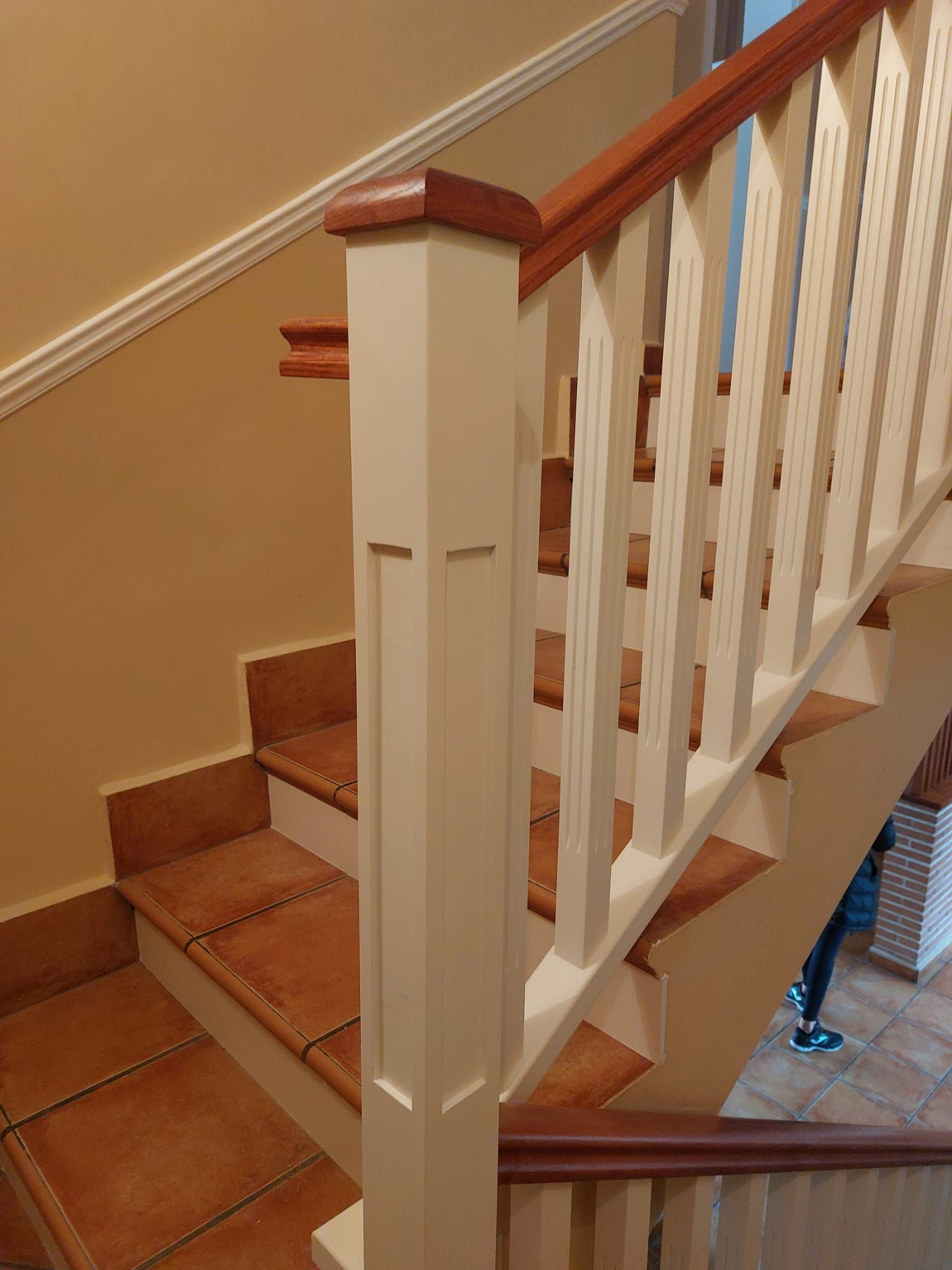 Una escalera con barandilla blanca y escalones de madera.