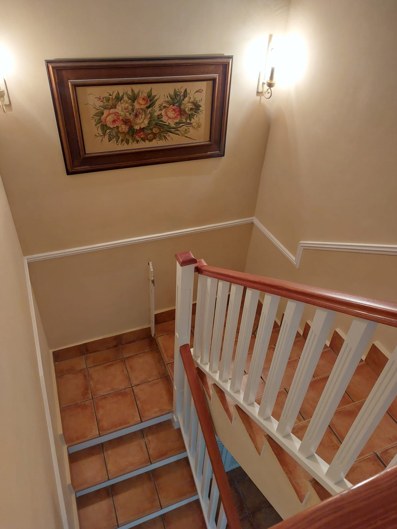 Una escalera con un cuadro en la pared encima.
