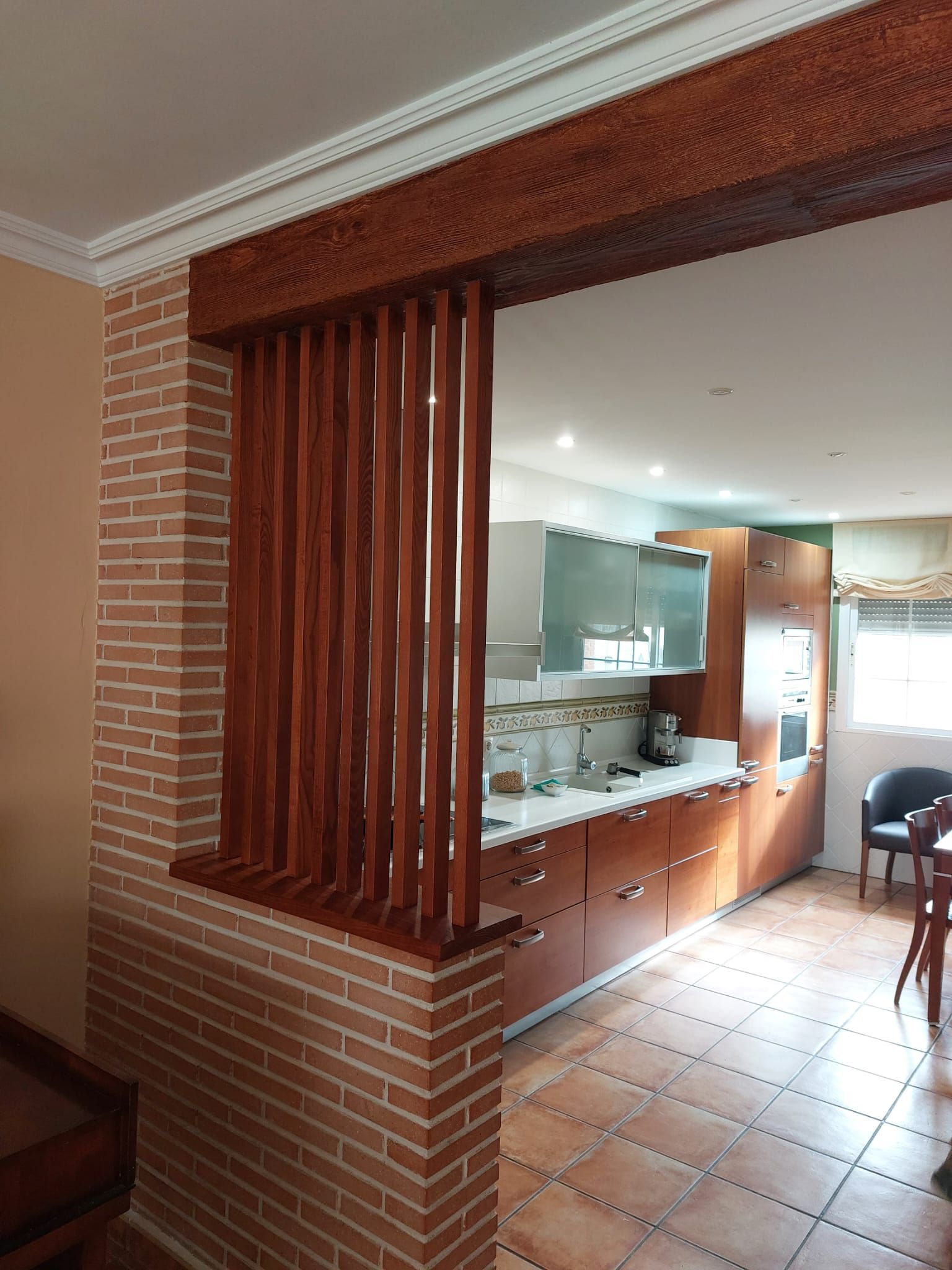 Una cocina con una pared de ladrillo y un divisor de madera.