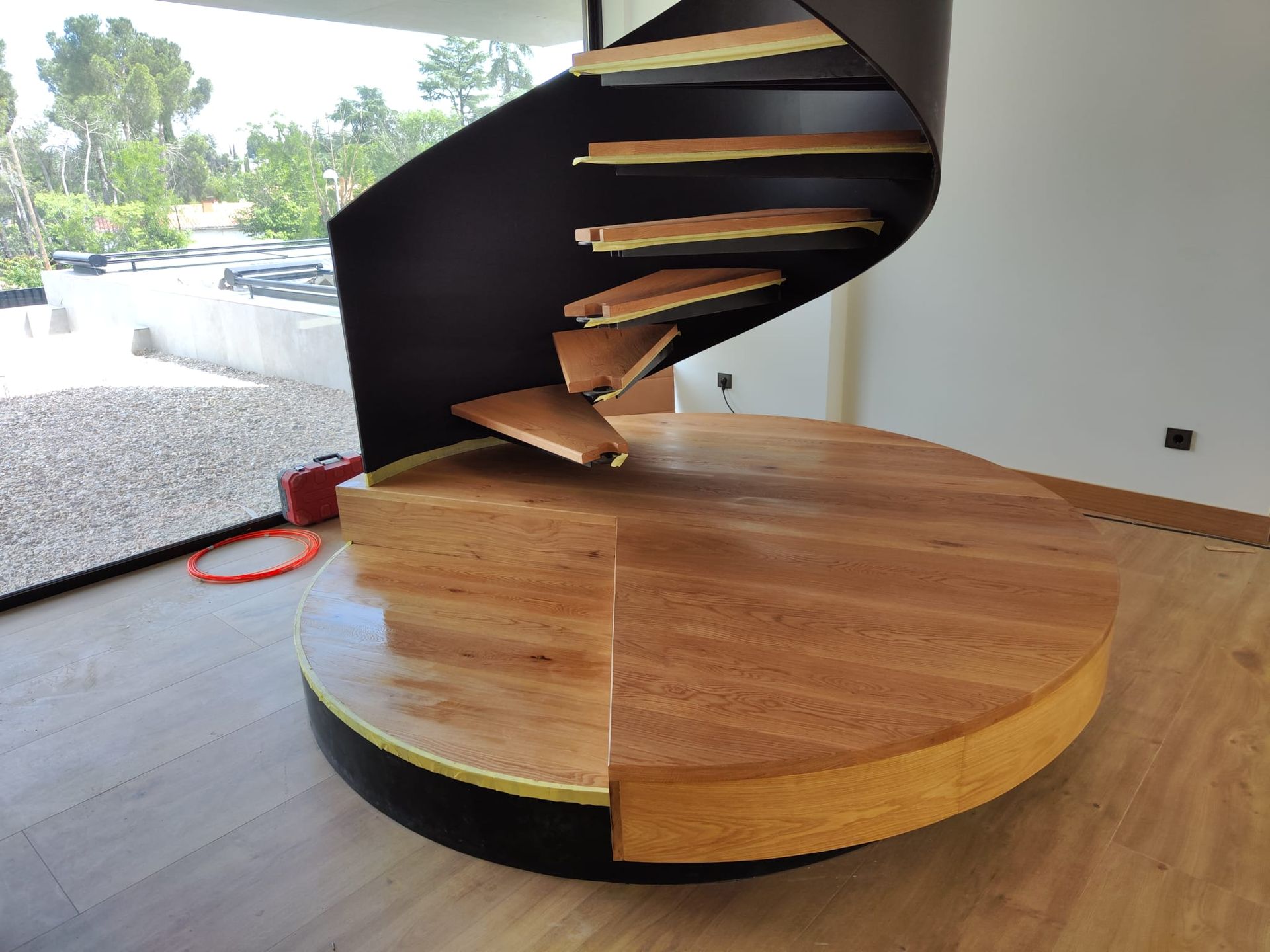 Una escalera de caracol se encuentra encima de una plataforma de madera.