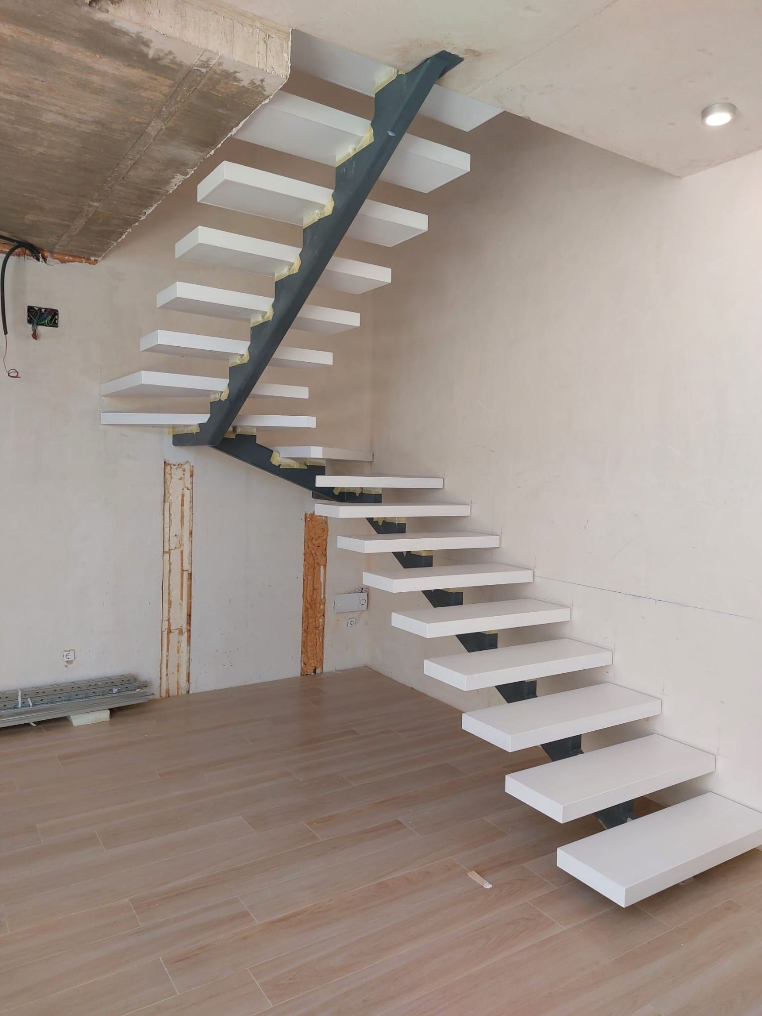 Se está construyendo una escalera en una habitación con suelo de madera.