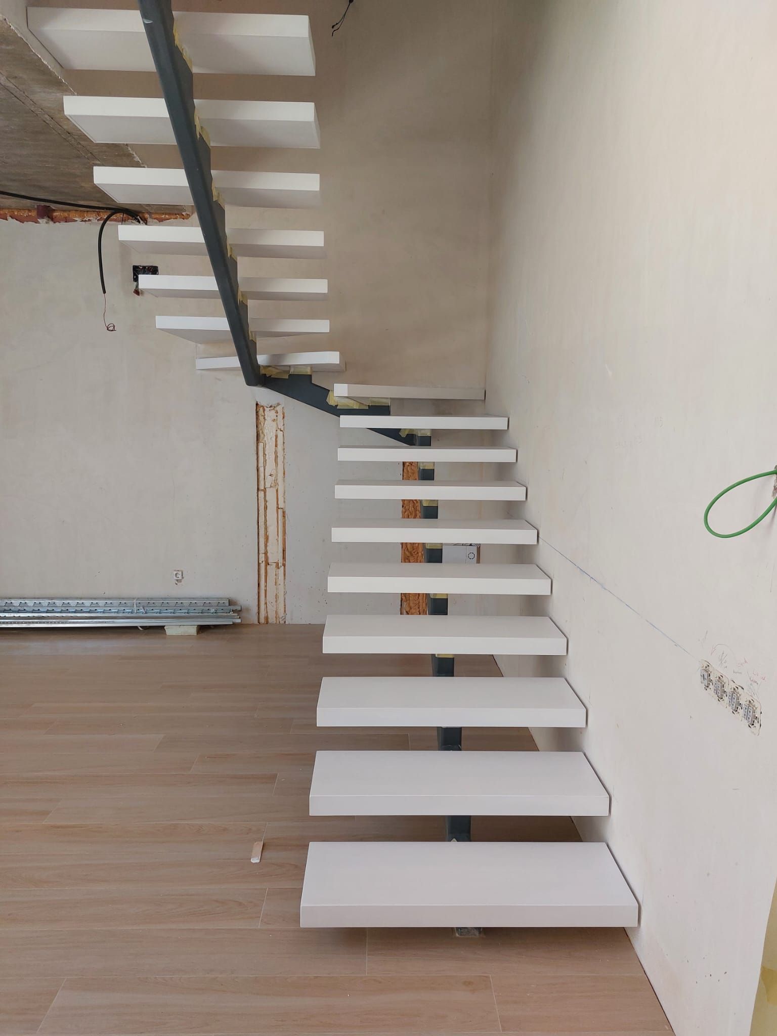 Se está construyendo una escalera blanca en una habitación.