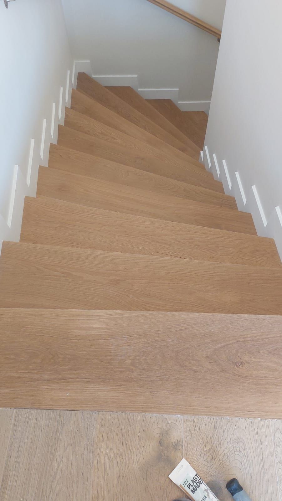 Un primer plano de una escalera de madera en una casa.