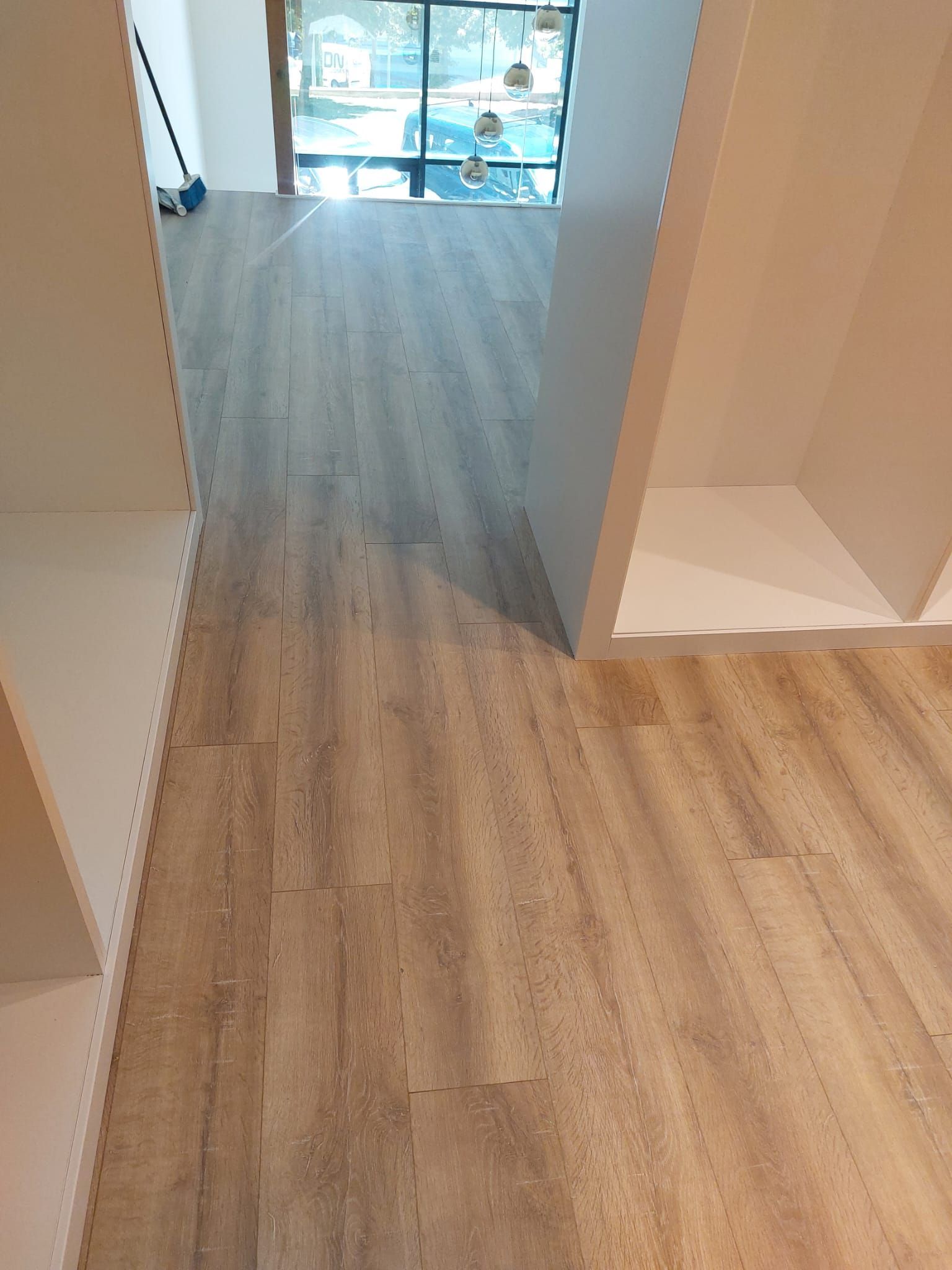 Un pasillo con suelo de madera y una ventana.