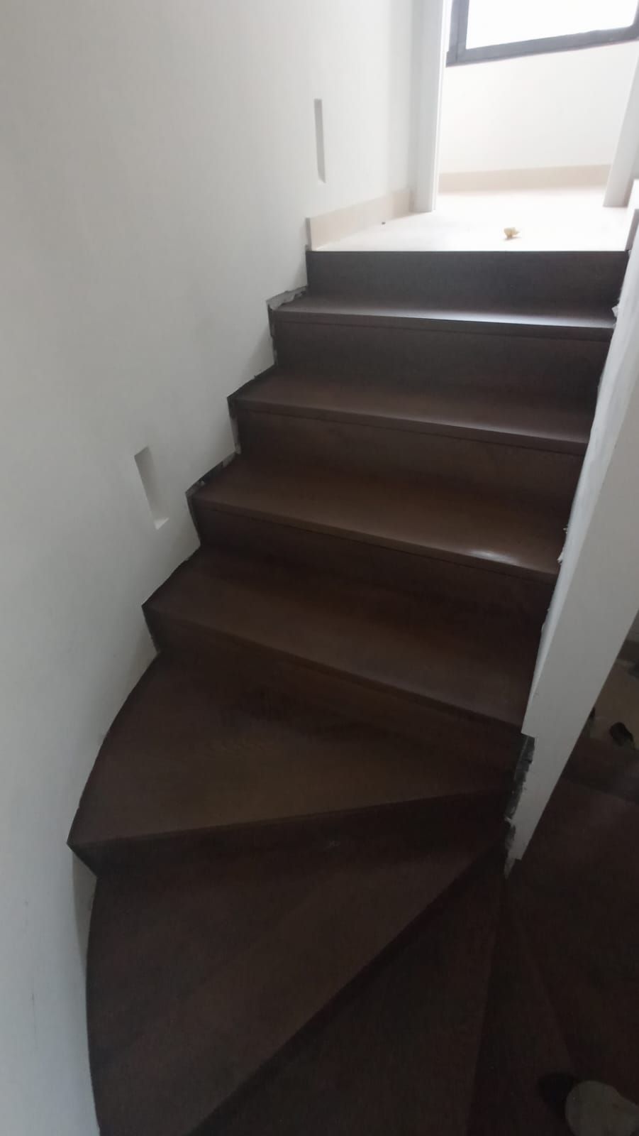Un primer plano de una escalera de madera en una casa.