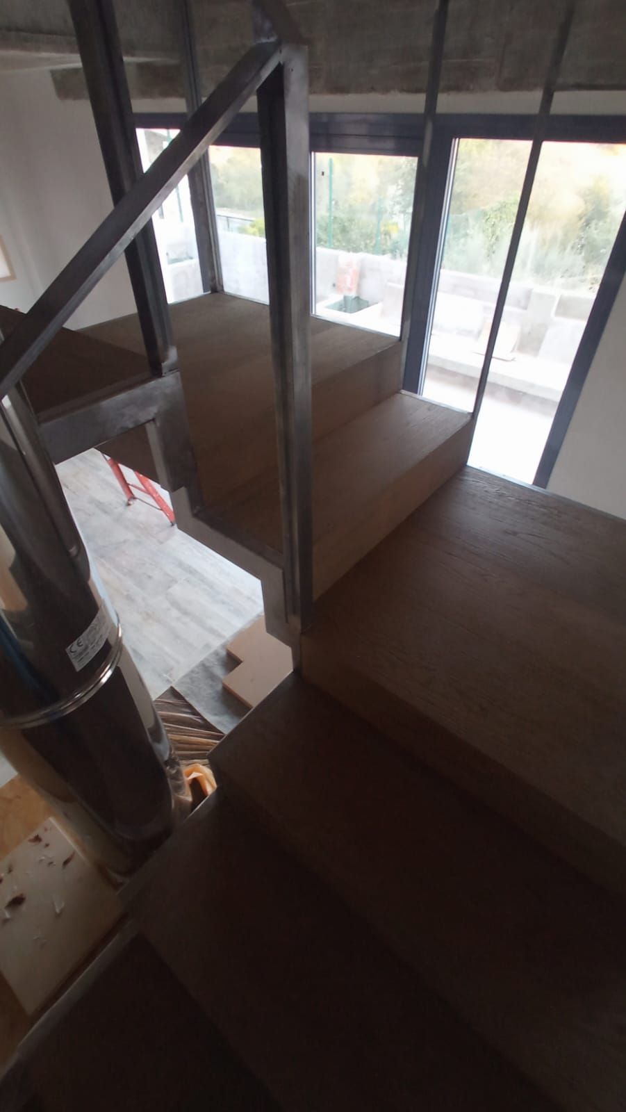 Una escalera de madera con barandilla de metal en una casa.
