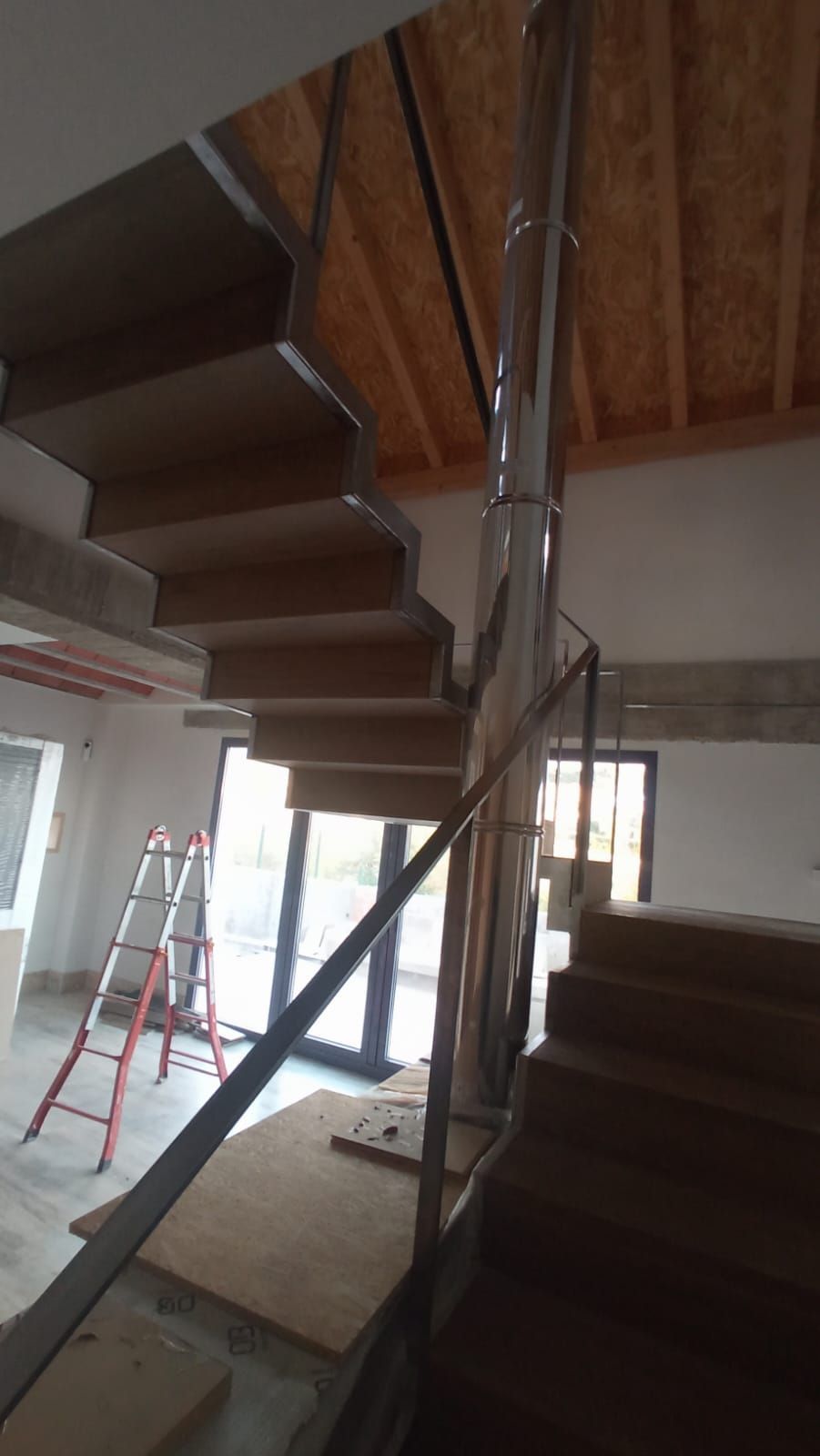 Se está construyendo una escalera con barandilla de cristal en una casa.