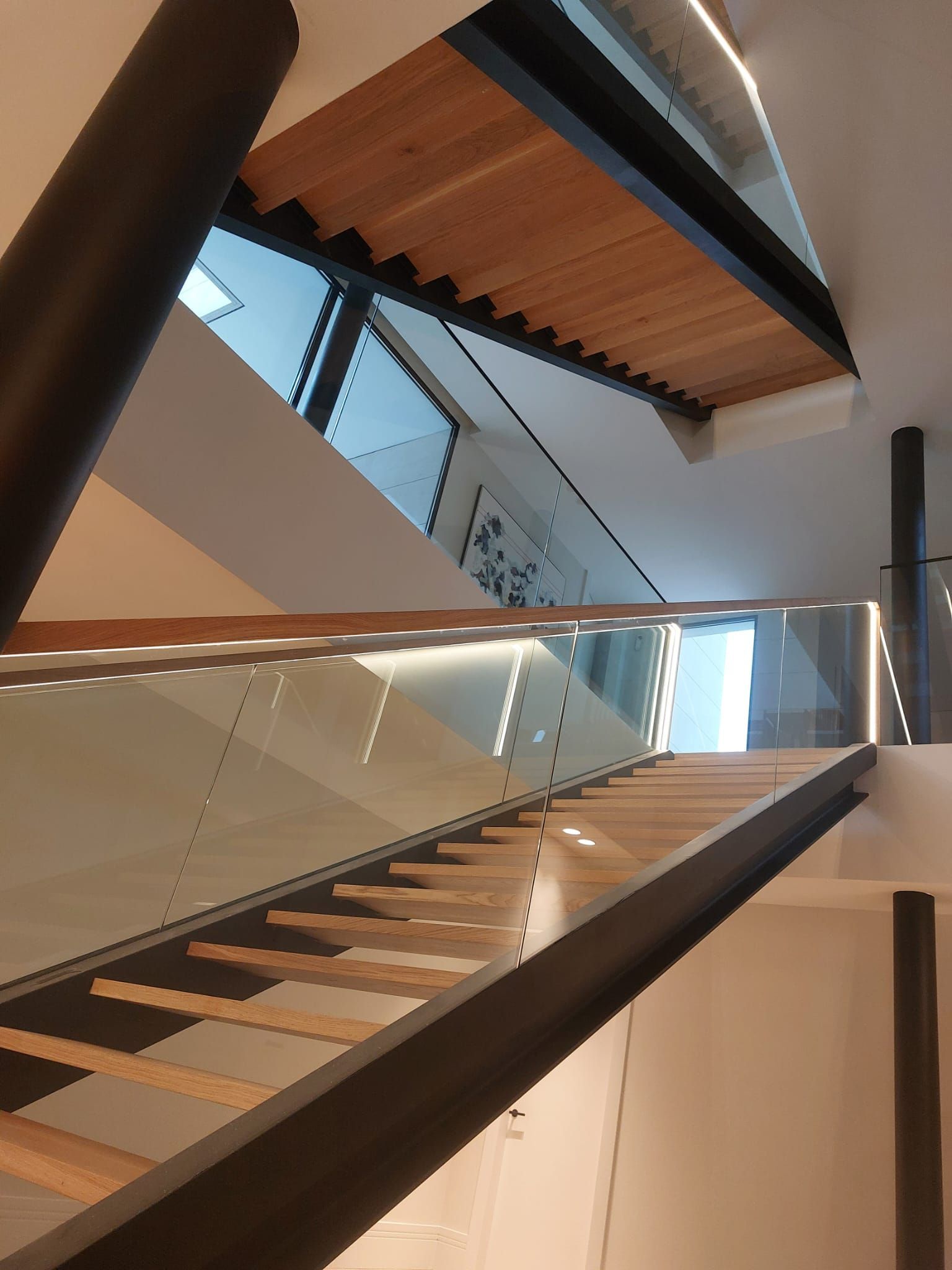 Mirando hacia arriba a una escalera con barandilla de vidrio