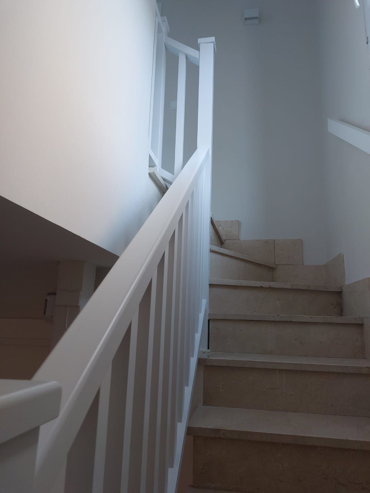 Un conjunto de escaleras con barandilla blanca.