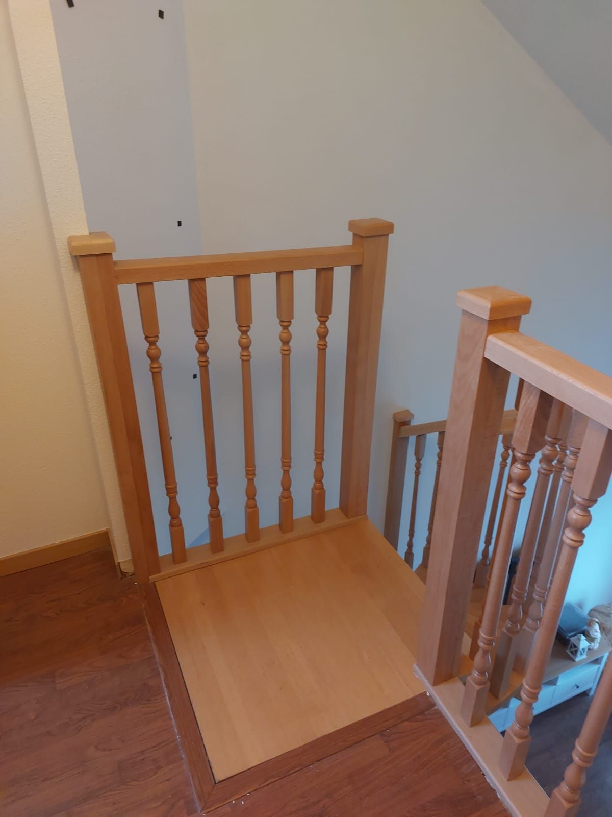 Una escalera de madera con una barandilla de madera y una plataforma de madera