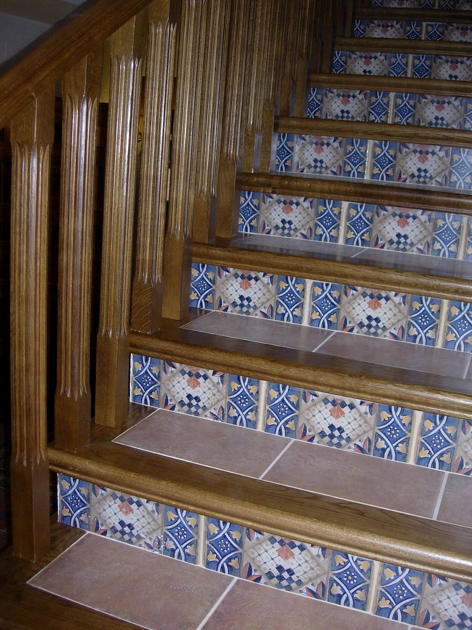 Un conjunto de escaleras de baldosas con barandilla de madera.