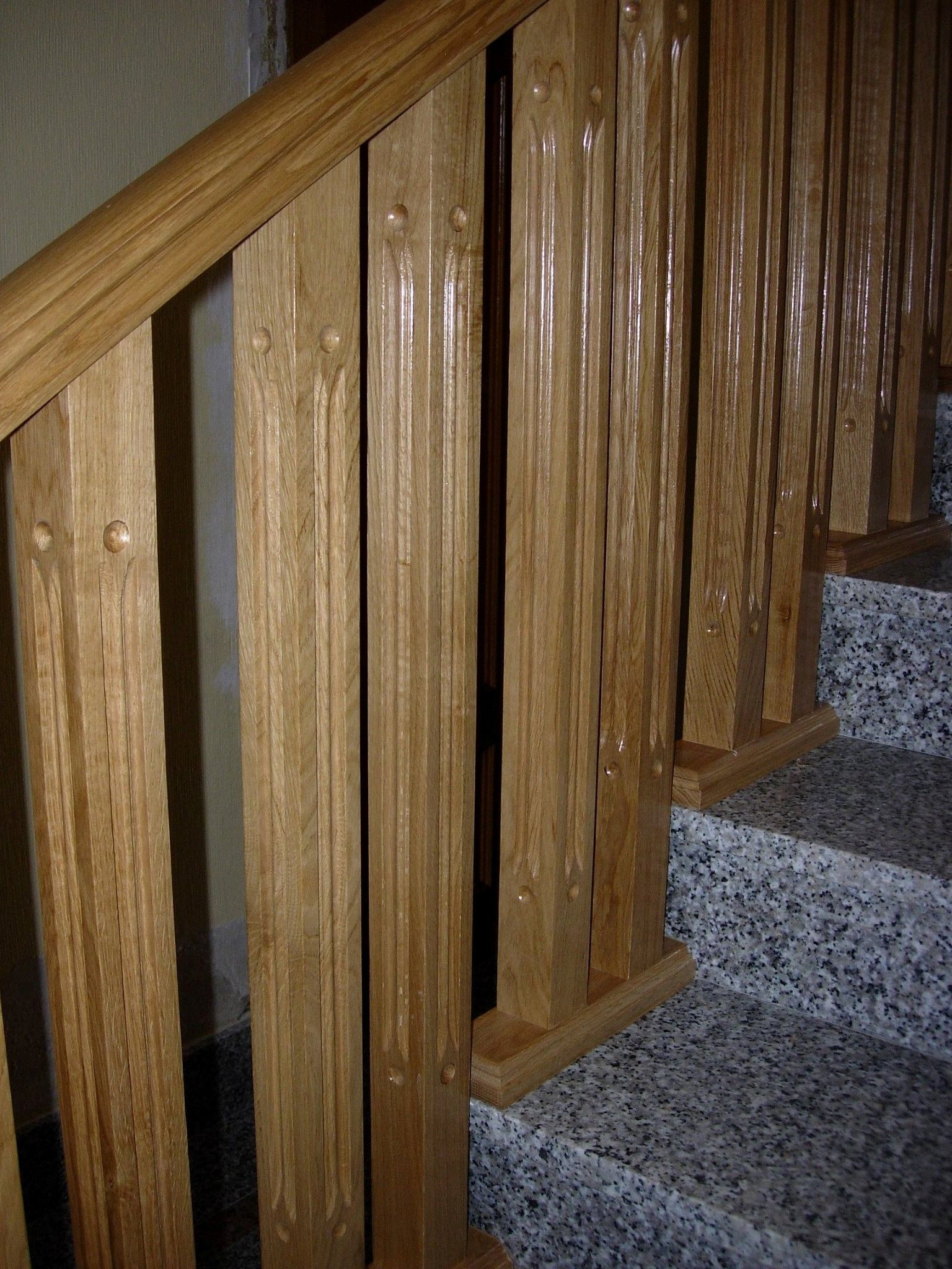 Un primer plano de una barandilla de madera en un conjunto de escaleras.